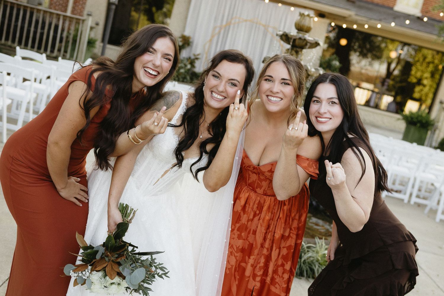 Wedding party members in burgundy and navy dresses pose together during celebrations.