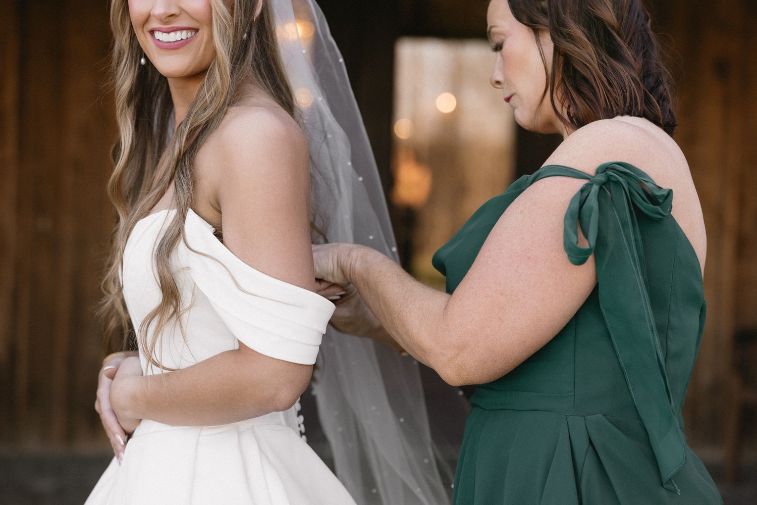 Wedding party members in emerald green dresses and white gown interacting during celebration.