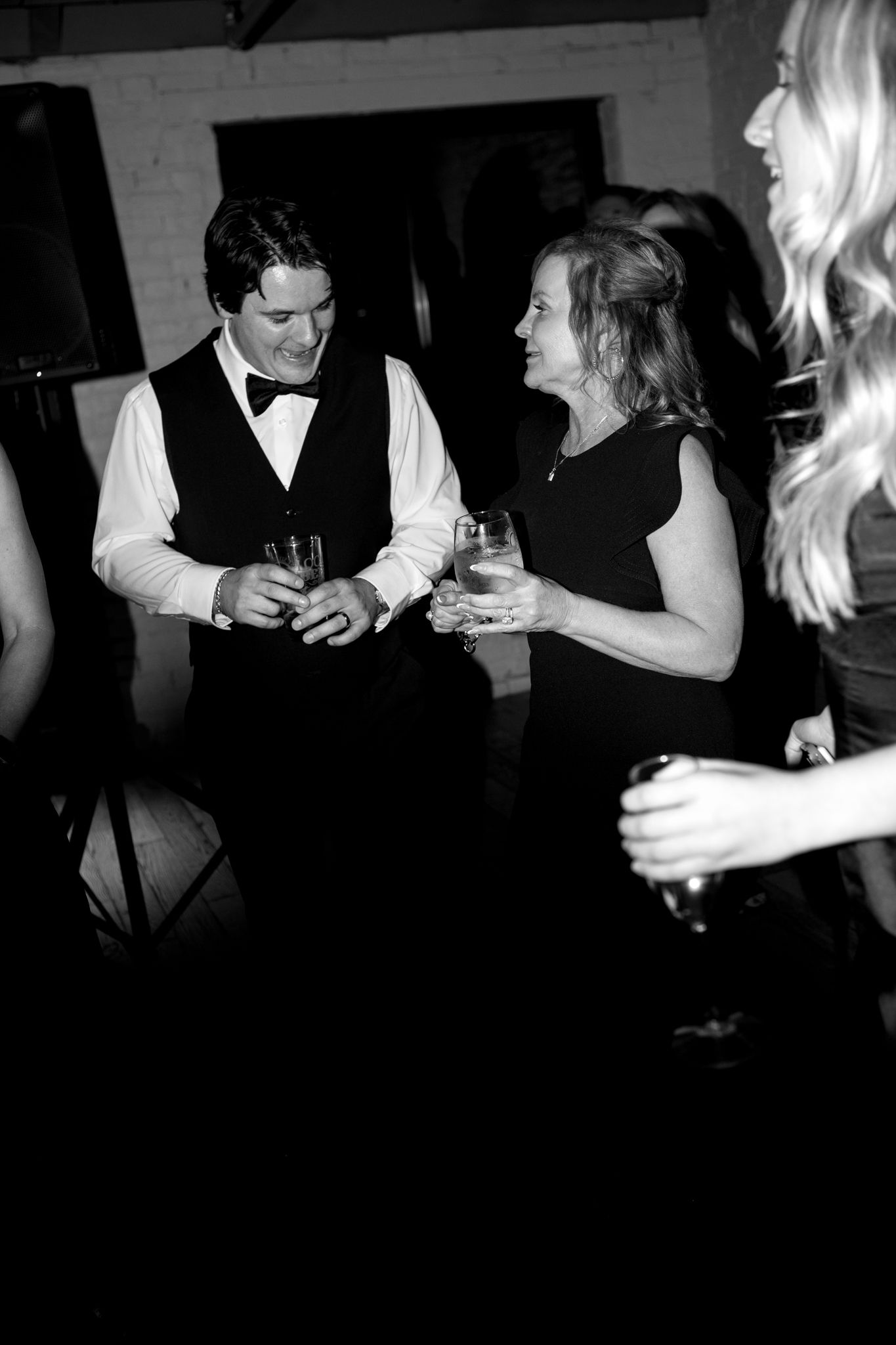 Guests mingle and chat while holding drinks during an elegant evening reception.