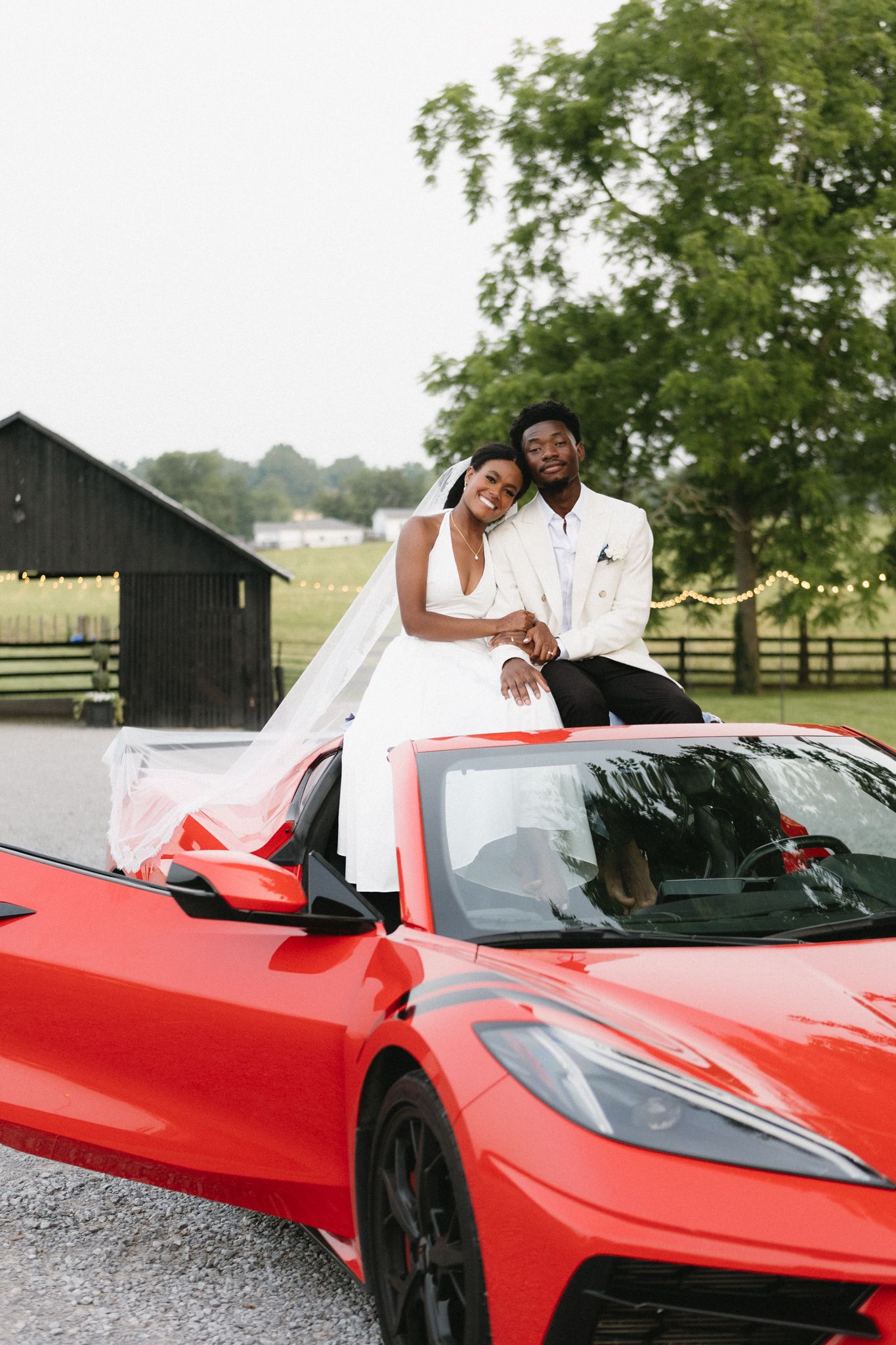A celebration with a sleek red Ferrari sports car serving as a backdrop on a sunny day.
