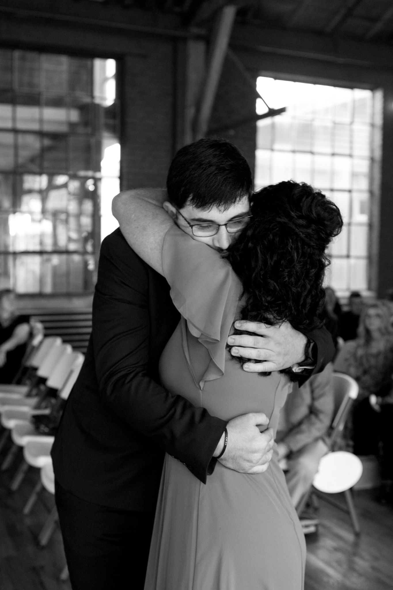 black and white photo groom and mother of the groom walking down the aisle waiting for bride
