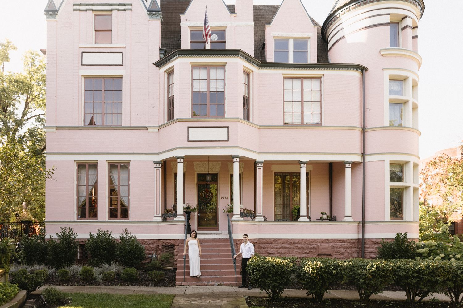Elegant white Victorian mansion with ornate architectural details and wrap-around porch showcases classic period design.