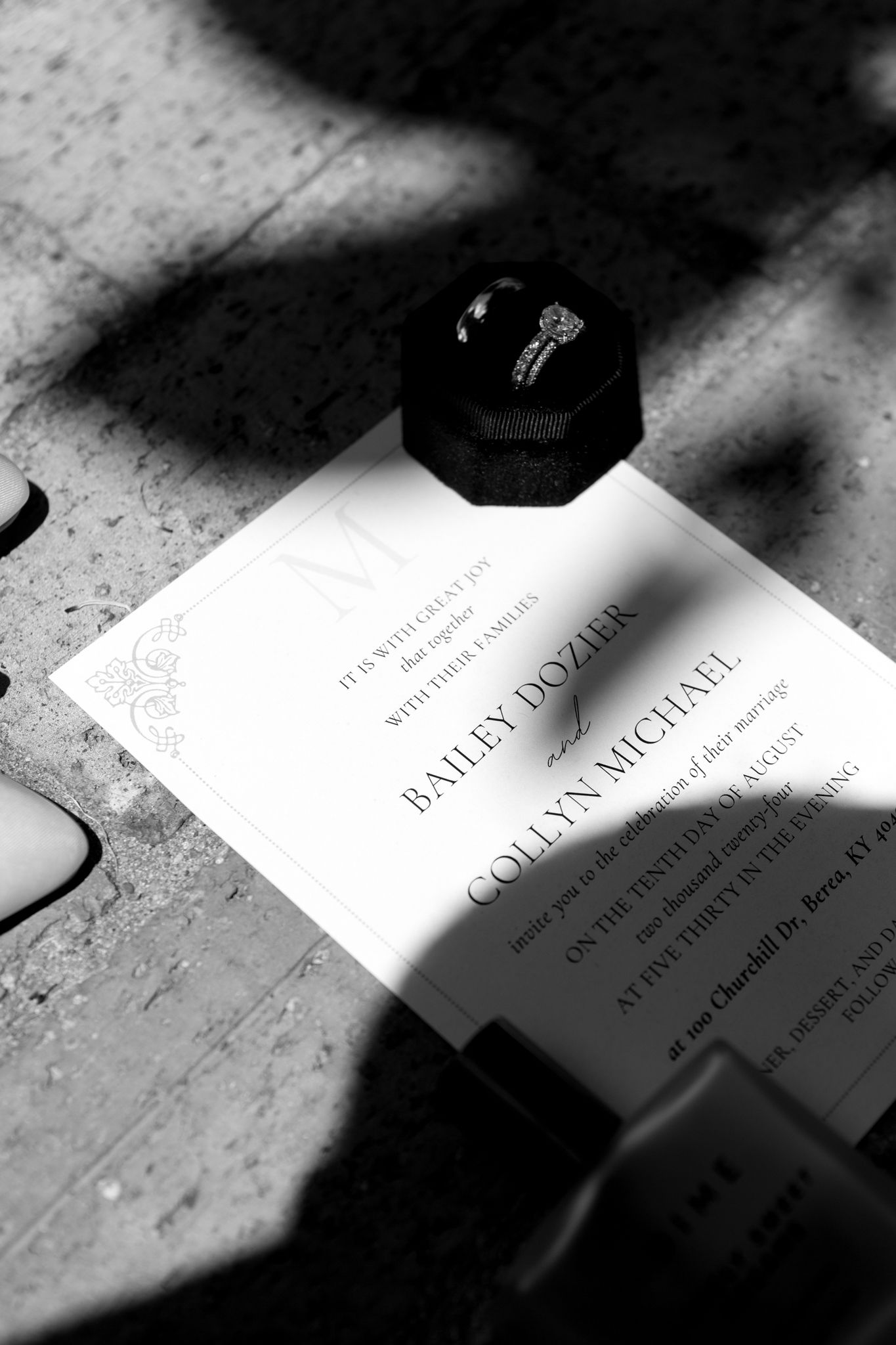 A beautifully designed wedding invitation, paired with stylish shoes and a shimmering wedding ring