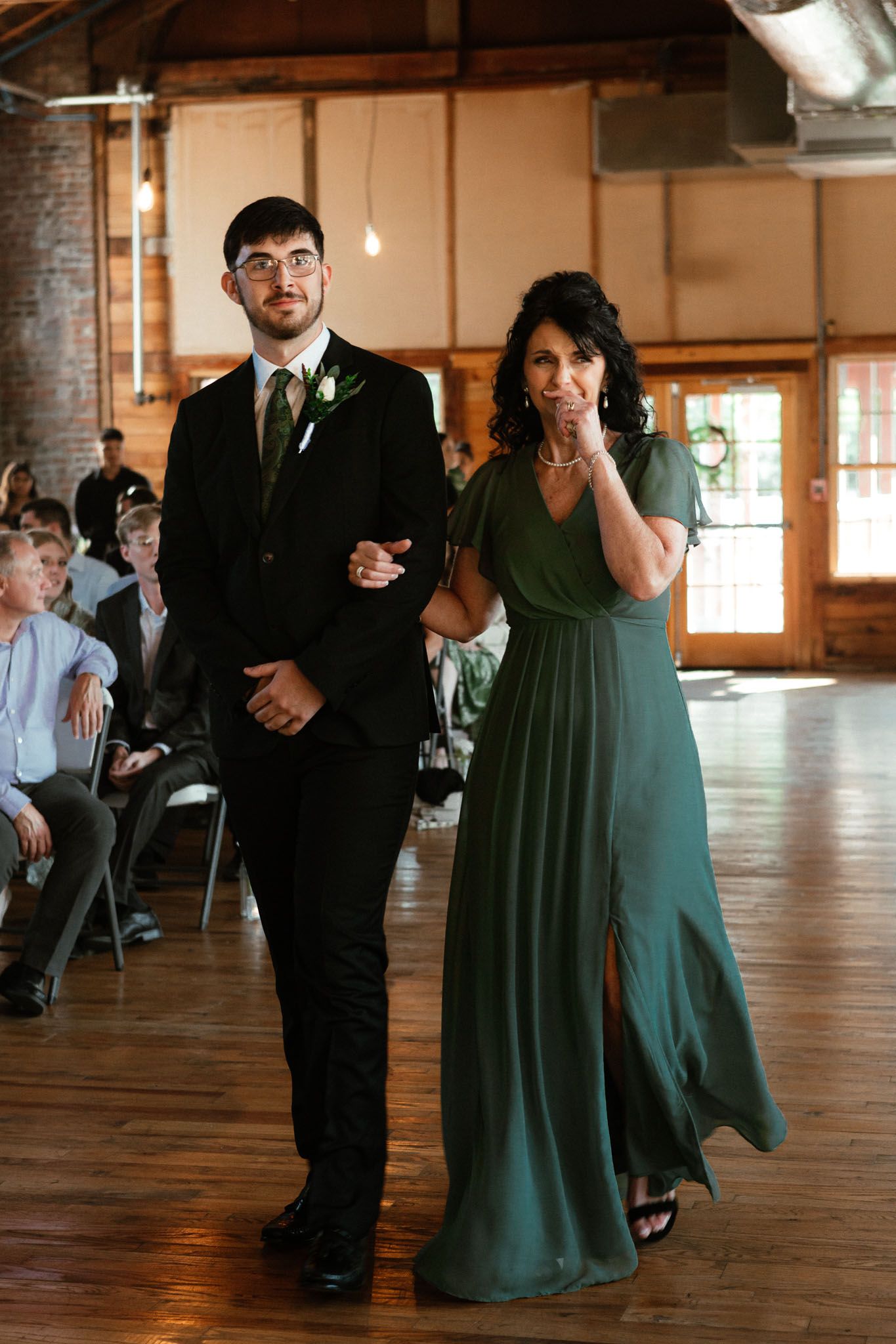 groom and mother of the groom walking down the aisle waiting for bride