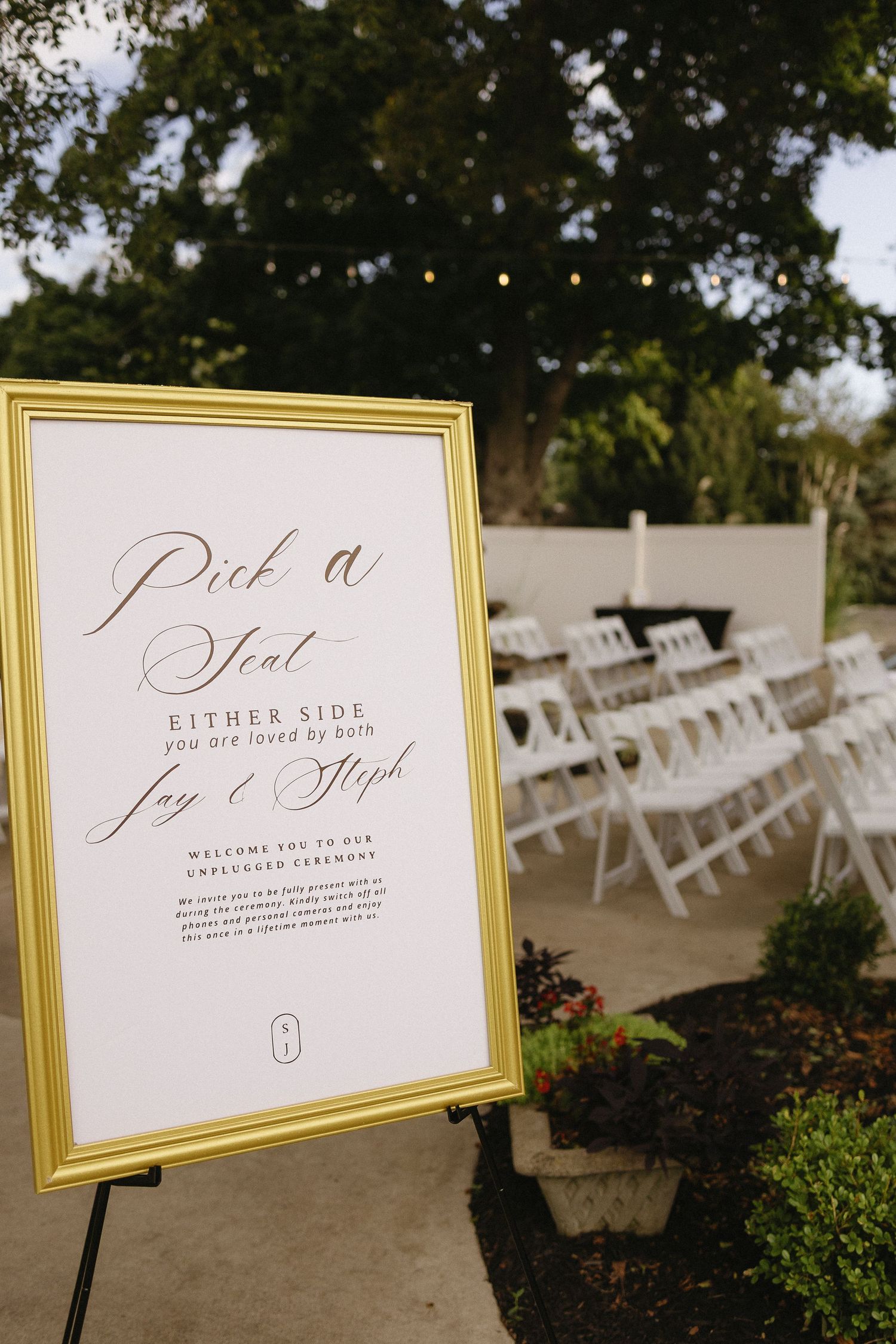 Wedding ceremony seating area with gold-framed directional signs.