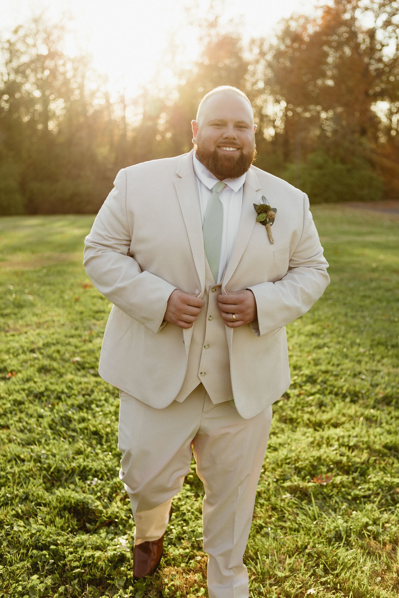 A cream-colored wedding suit shown from different angles in warm evening sunlight.