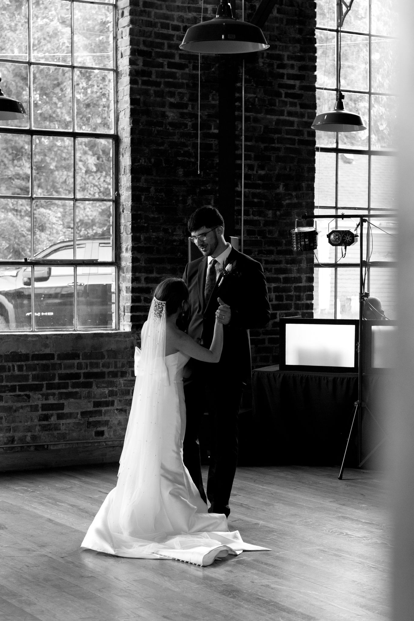 black and white photo Bride and groom sharing a romantic first dance at an outdoor reception