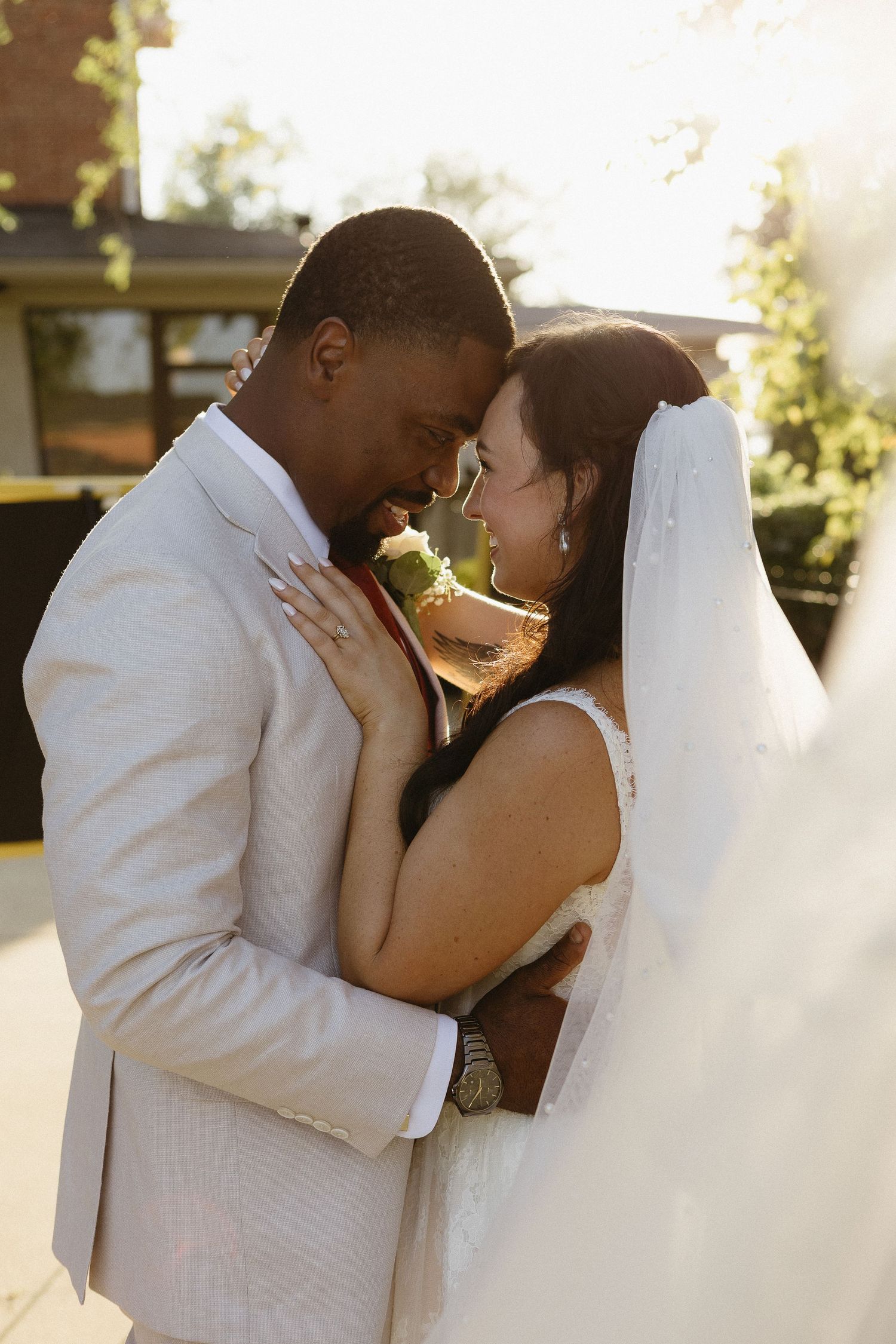 Romantic sunset wedding portraits with couple in white attire.