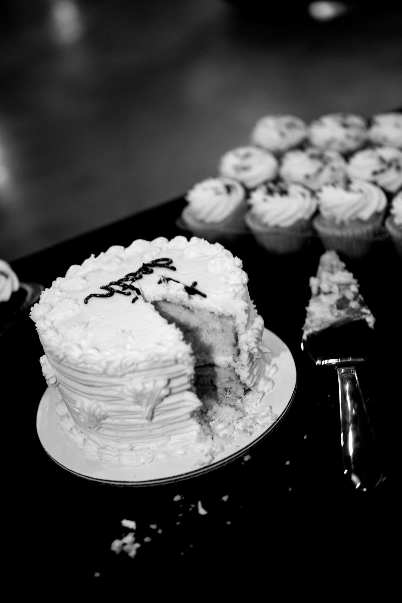 Black and white photos of a wedding cake and cupcakes arranged on plates.