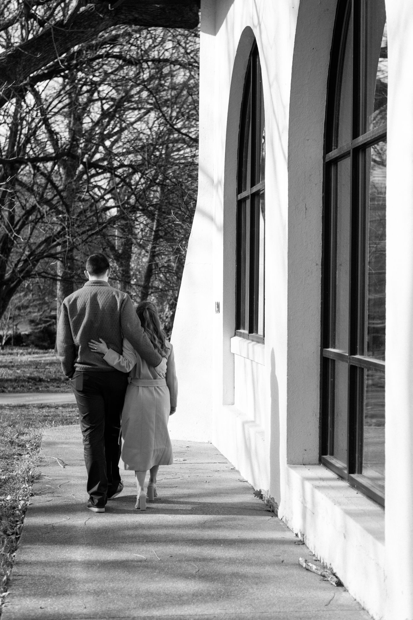 Chilly day engagement shoot in Old Louisville with couple embracing near iconic Victorian architecture.