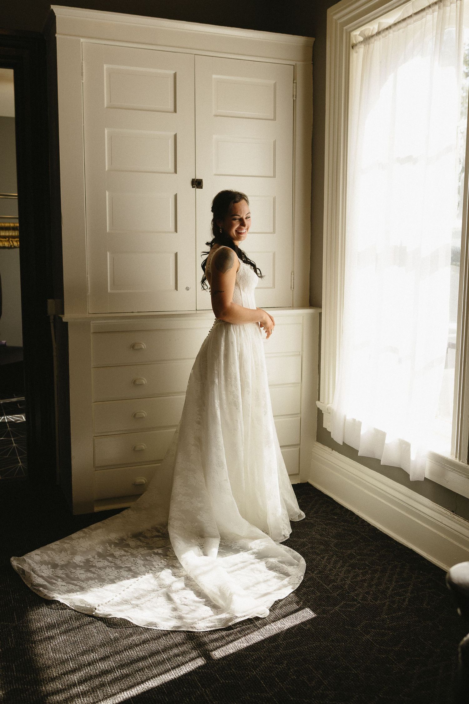 Dramatic bridal portraits by a window with white doors and natural light streaming in.
