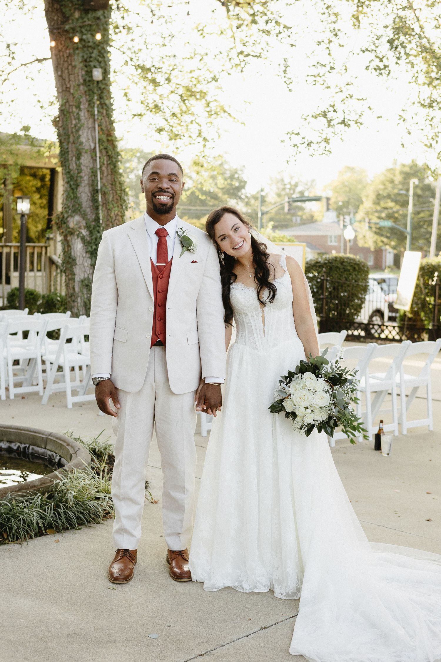 Newlyweds share a joyful moment together at their outdoor wedding venue.
