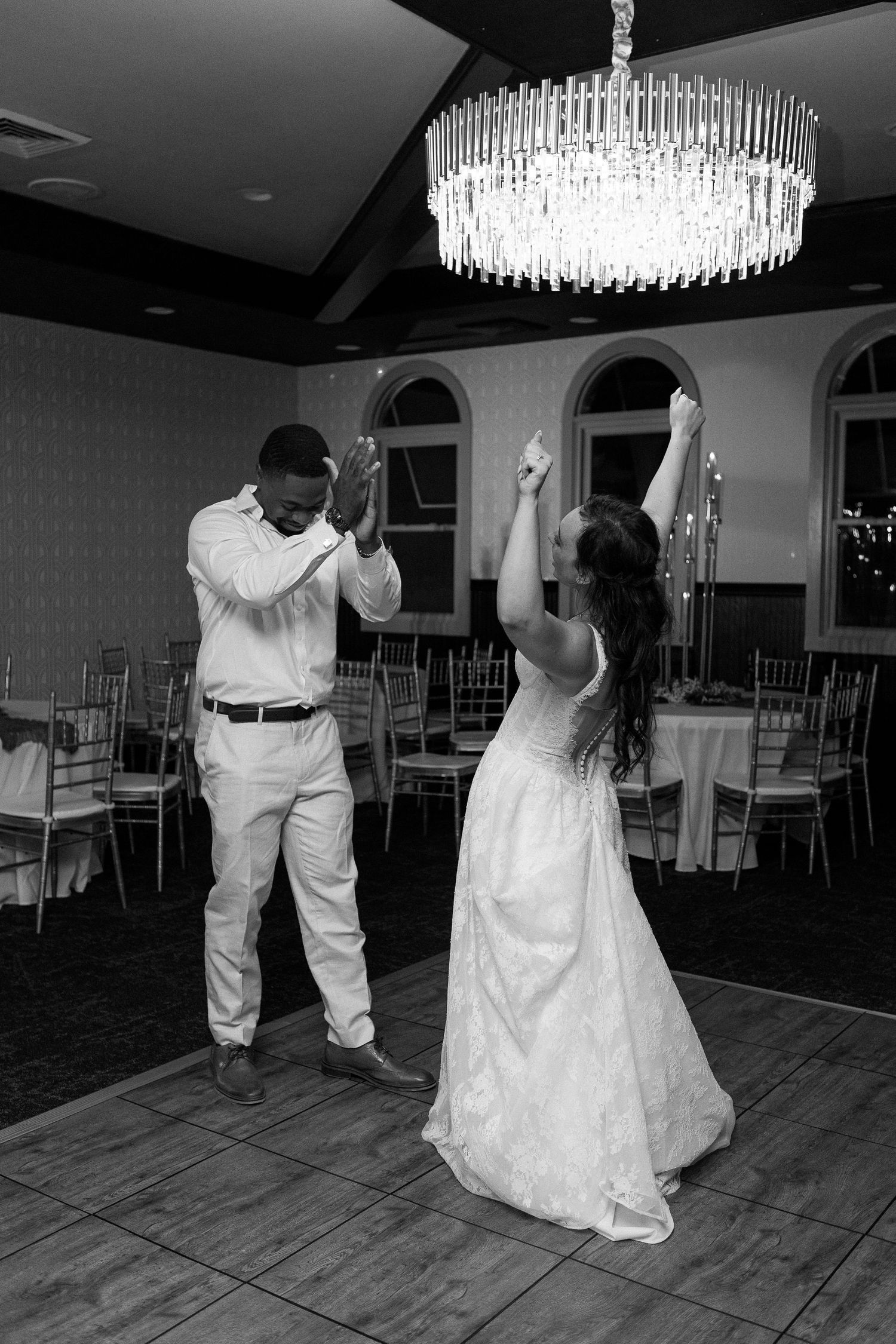 Black and white wedding dance sequence in an elegant ballroom with crystal chandeliers.