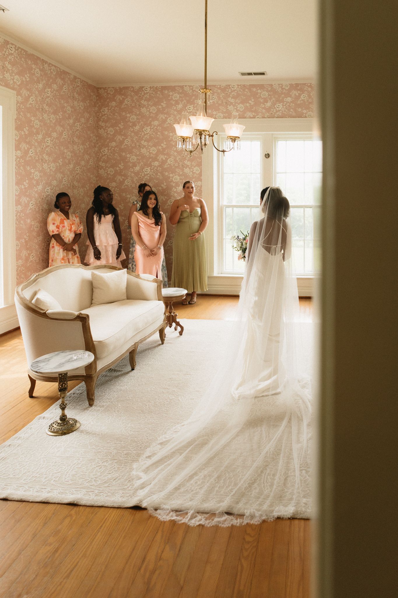 A stunning wedding dress train spread beautifully across hardwood floors in a vintage-style room.