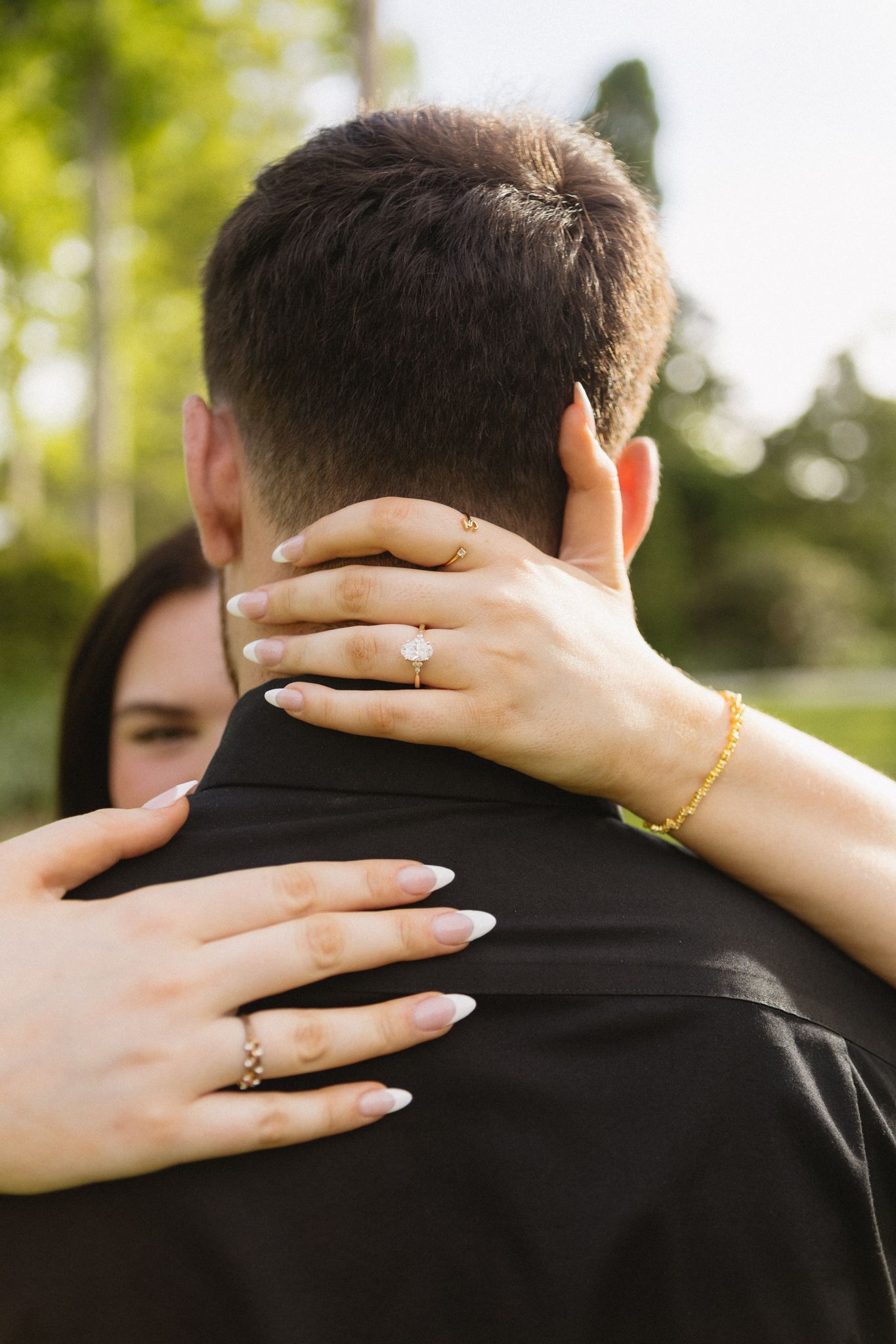 Delicate hands with gold rings embrace a shoulder in an intimate close-up photo series.
