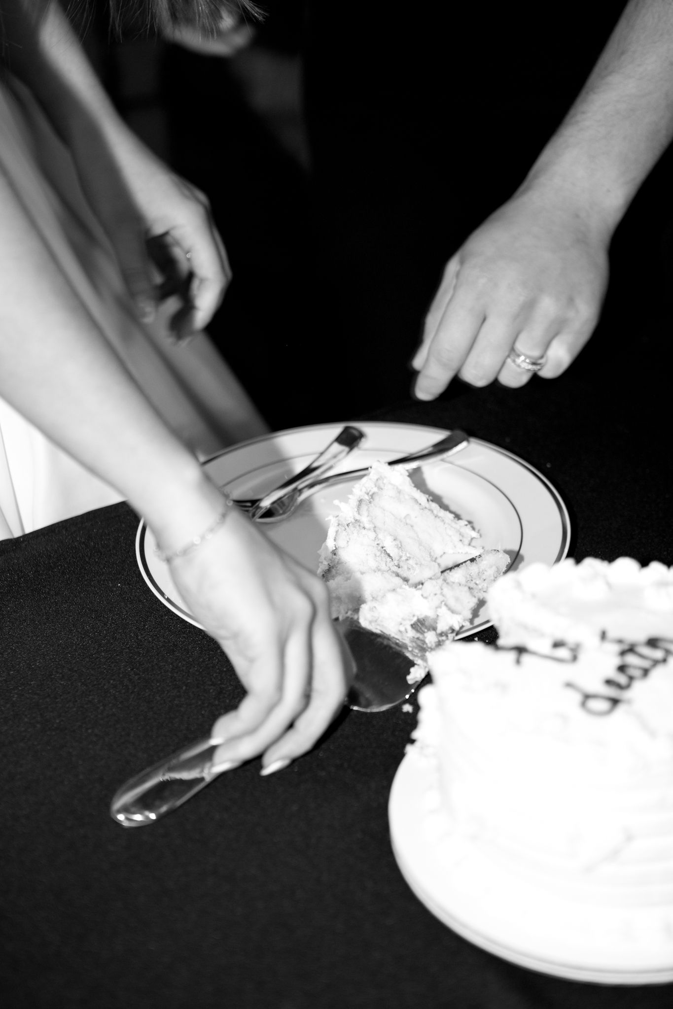 Series of black and white images showing hands cutting and serving wedding cake.