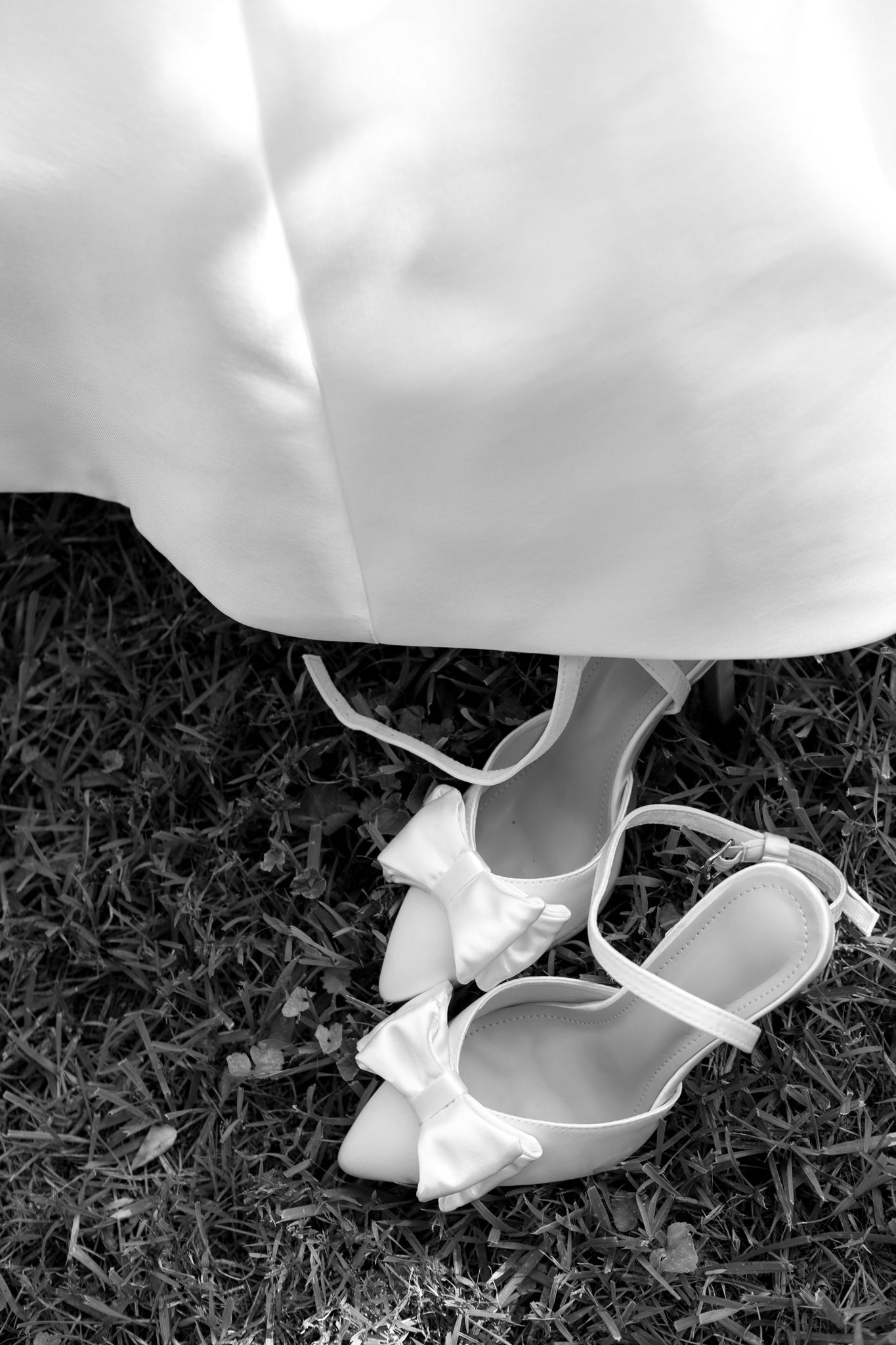 Elegant black and white photo showcasing a bride's delicate shoes, symbolizing grace and timeless beauty on her special