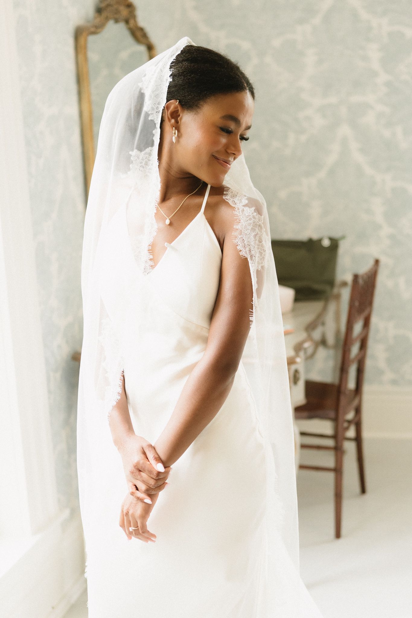 Elegant bridal portrait series showing close-up details of a white wedding dress and flowing veil against a light backdrop.