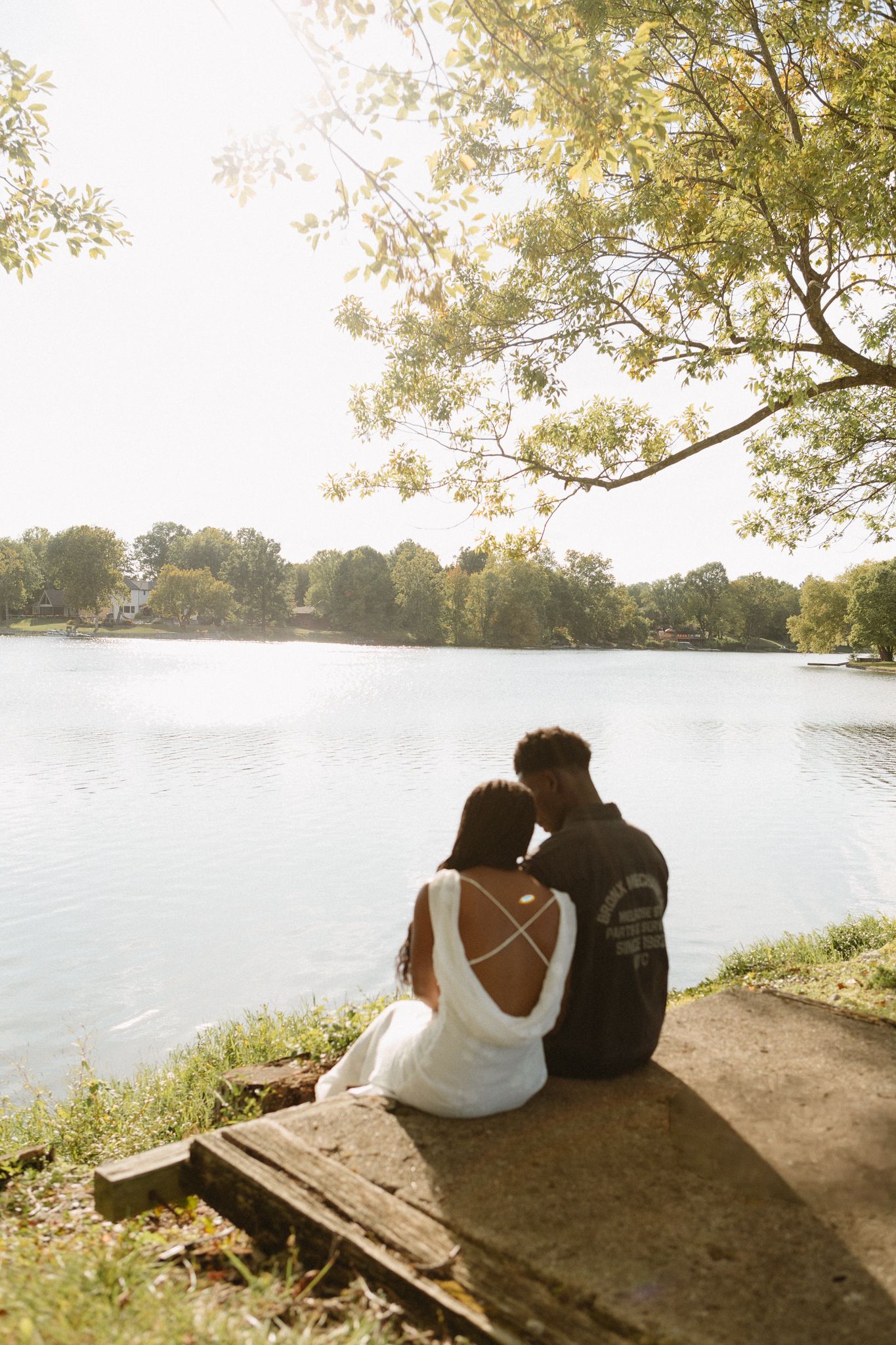 Engaged Black couple sharing a quiet, loving moment under tall trees in Lexington, KY.
