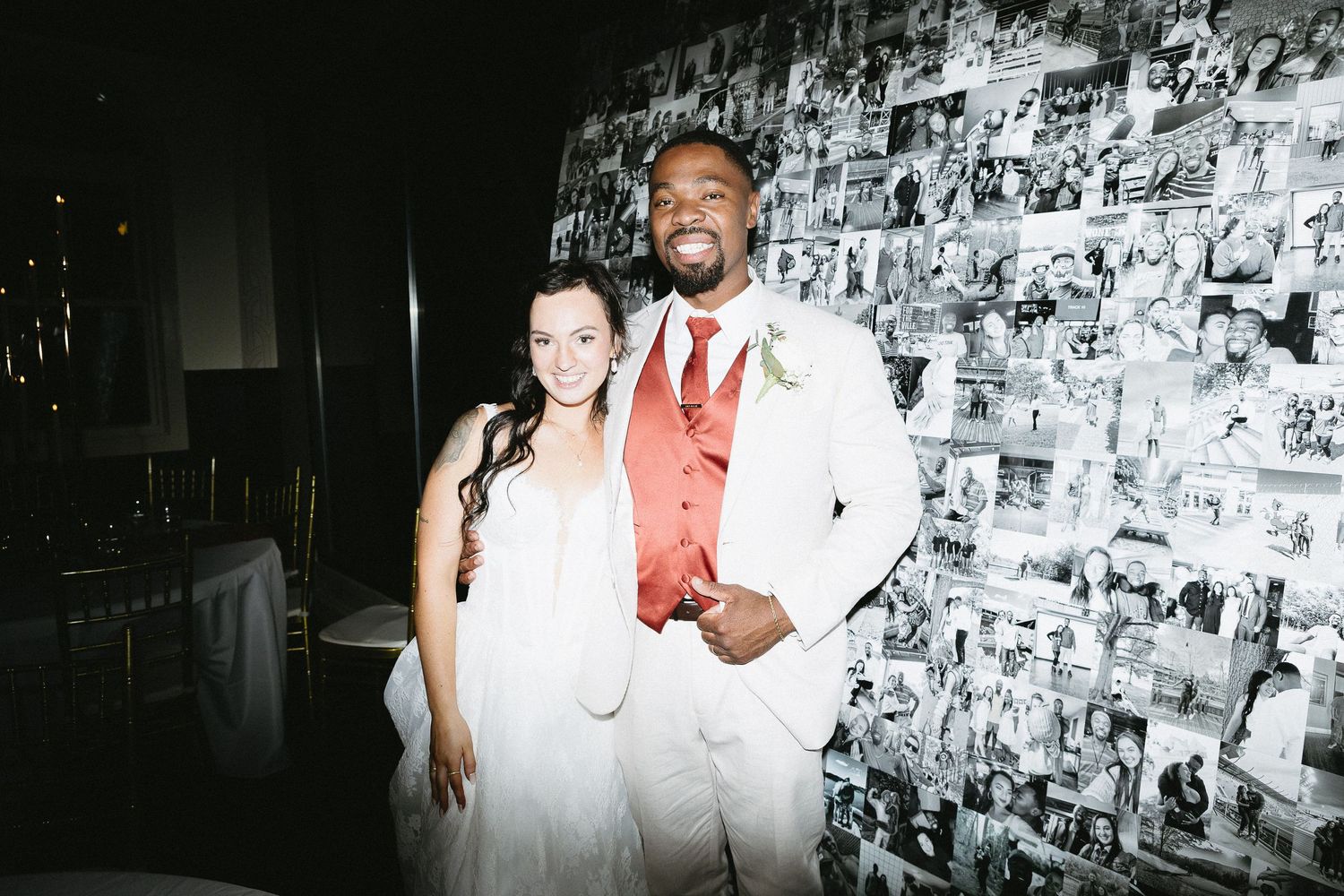 Black and white wedding photo against a wall covered in photographs.