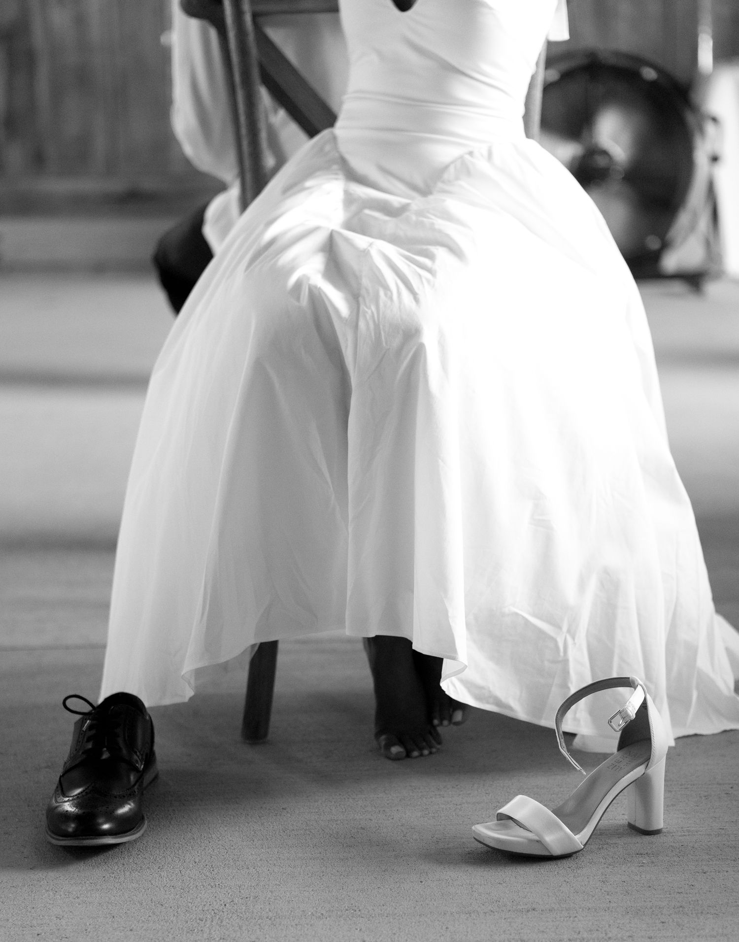 Close-up view of wedding dress and shoes during dance movements in black and white.