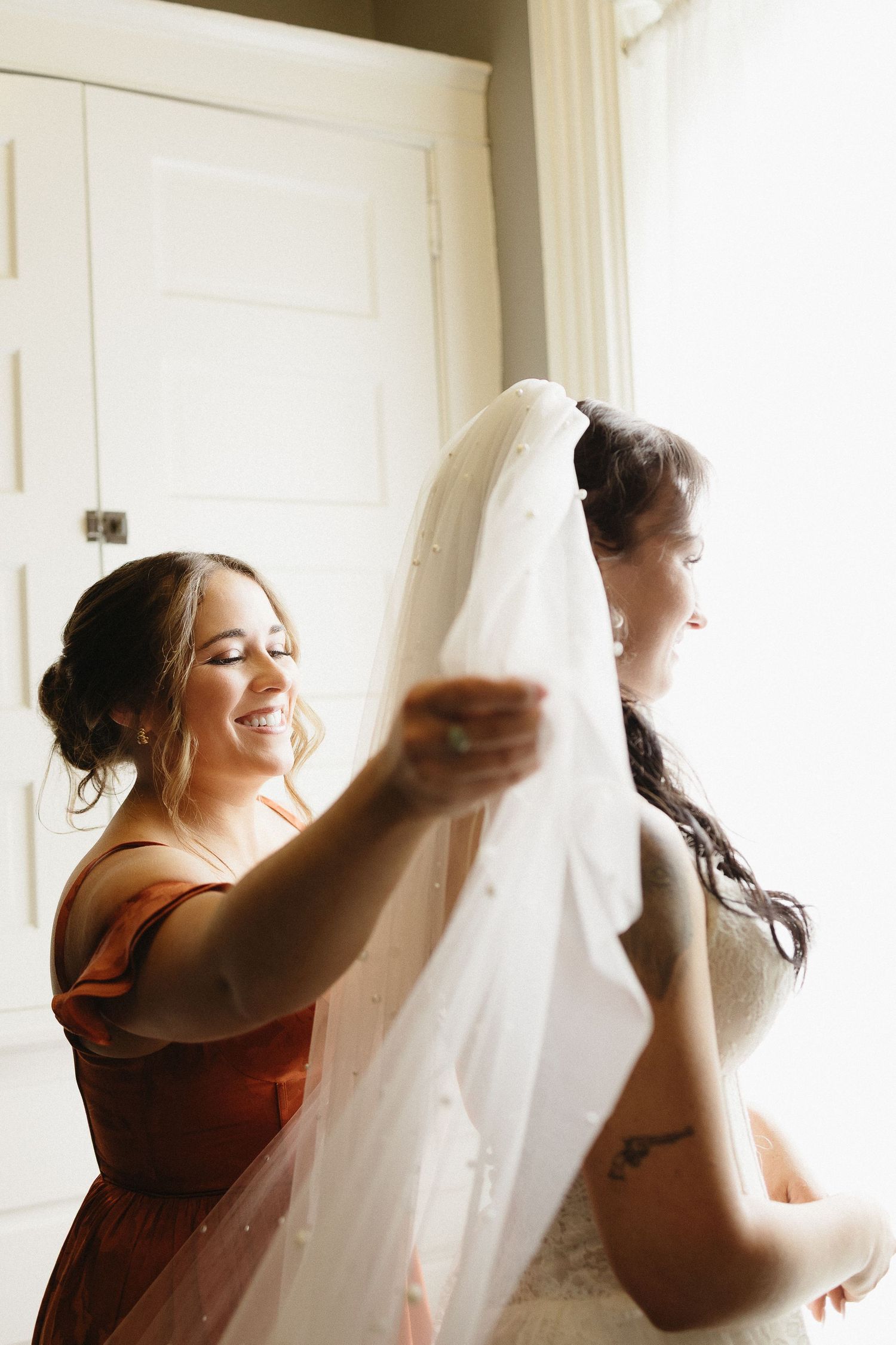 Joyful bridesmaids in burgundy dresses prepare for the wedding day.