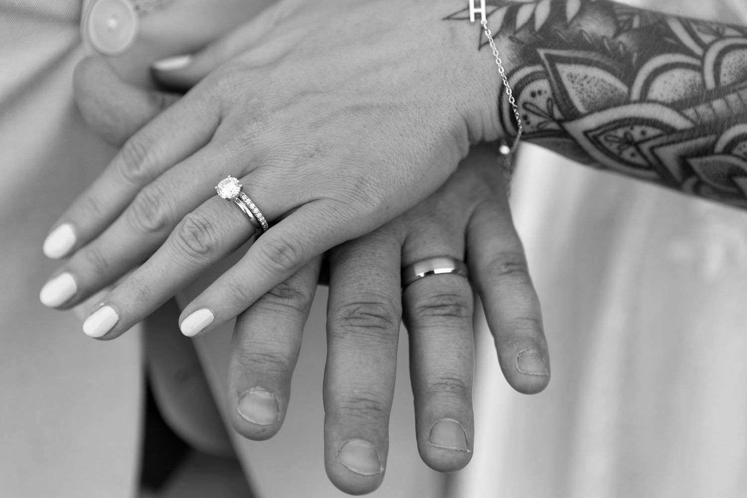 Close up of wedding rings and hands in black and white photography.