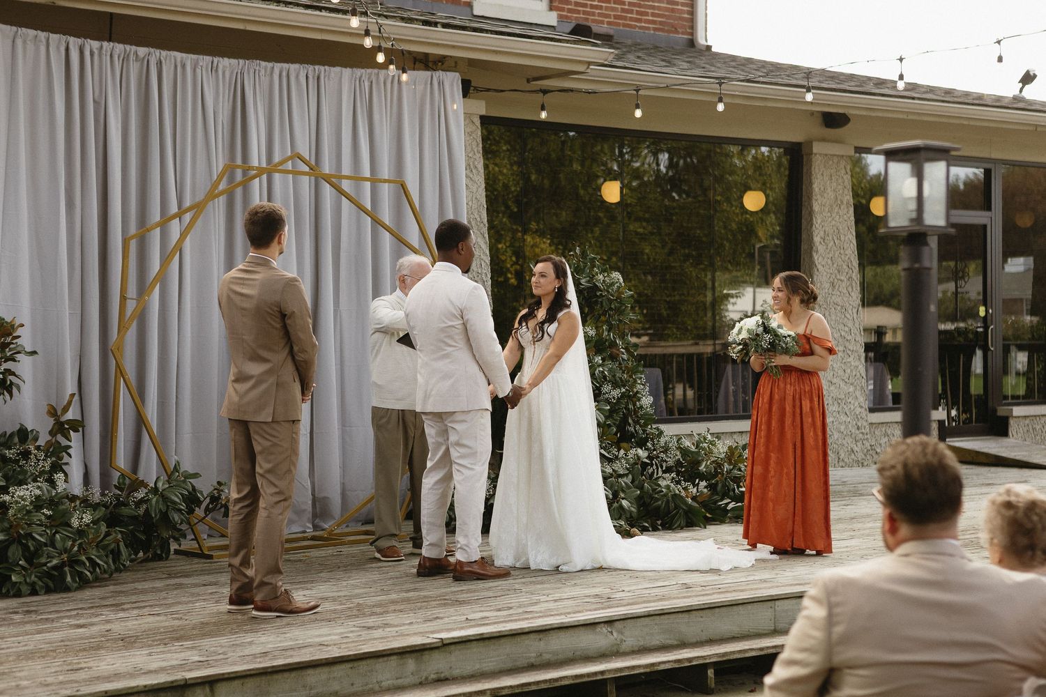 Outdoor wedding ceremony setup with white chairs and floral arrangements.