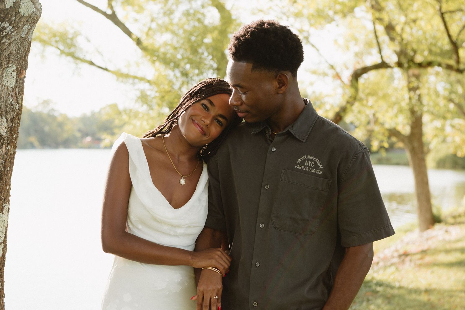 Engaged Black couple sharing a quiet, loving moment under tall trees in Lexington, KY.\