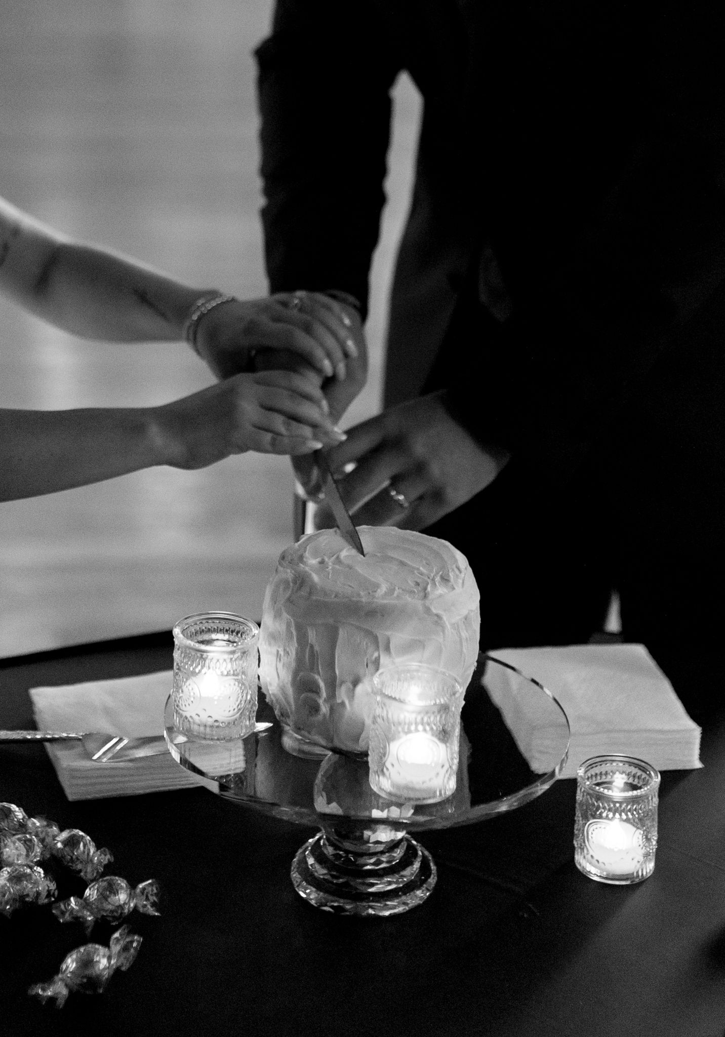black and white photo couple cutting small wedding cake