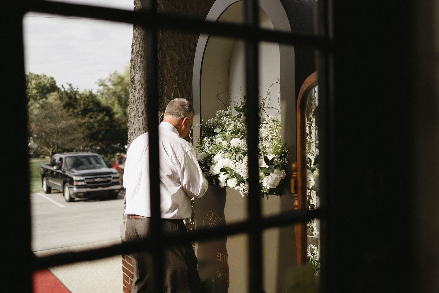 View through window of wedding venue with floral arrangements.
