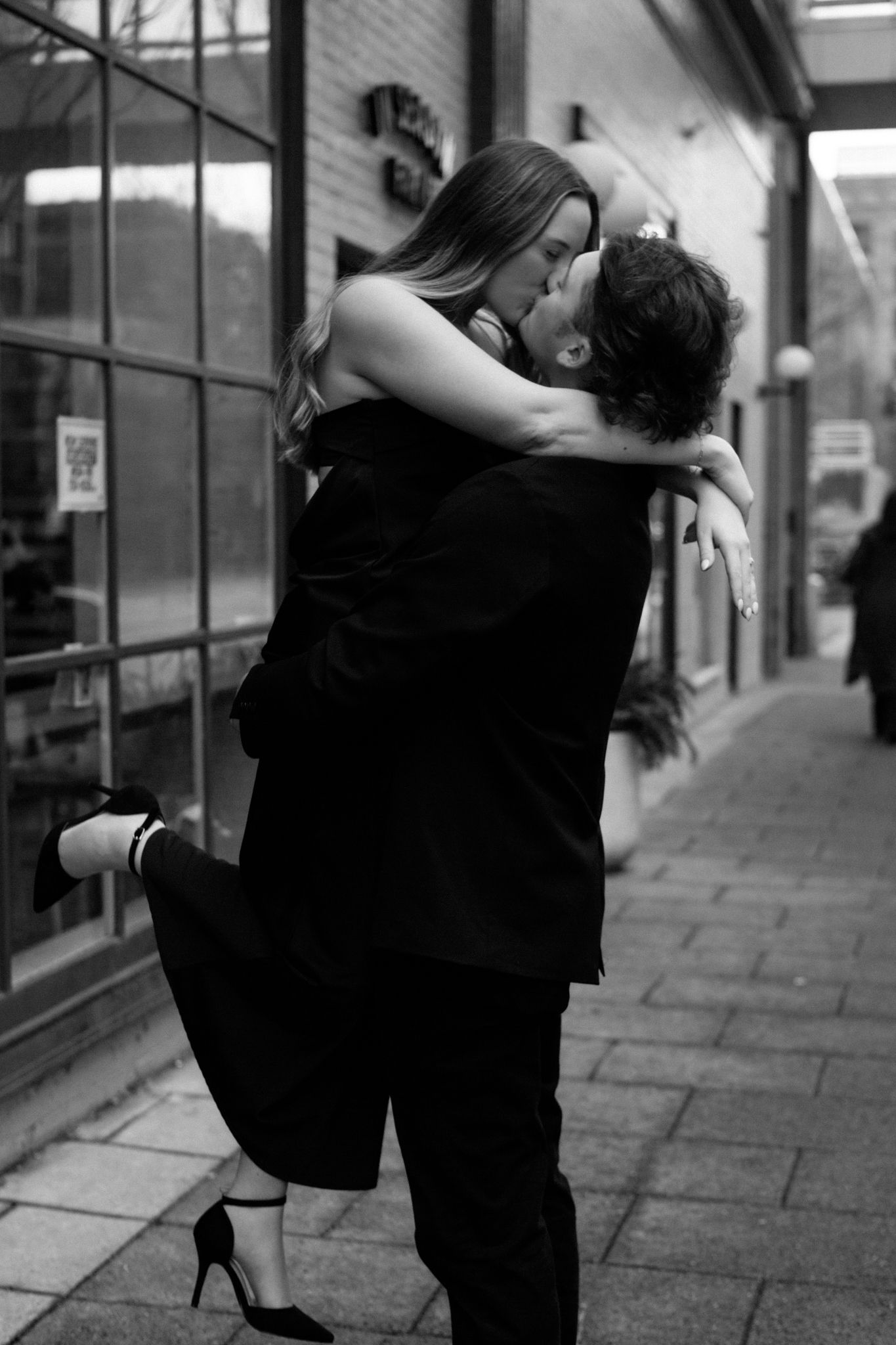 black and white photo of an engaged couple kissing and embracing, sharing an intimate moment in downtown Louisville