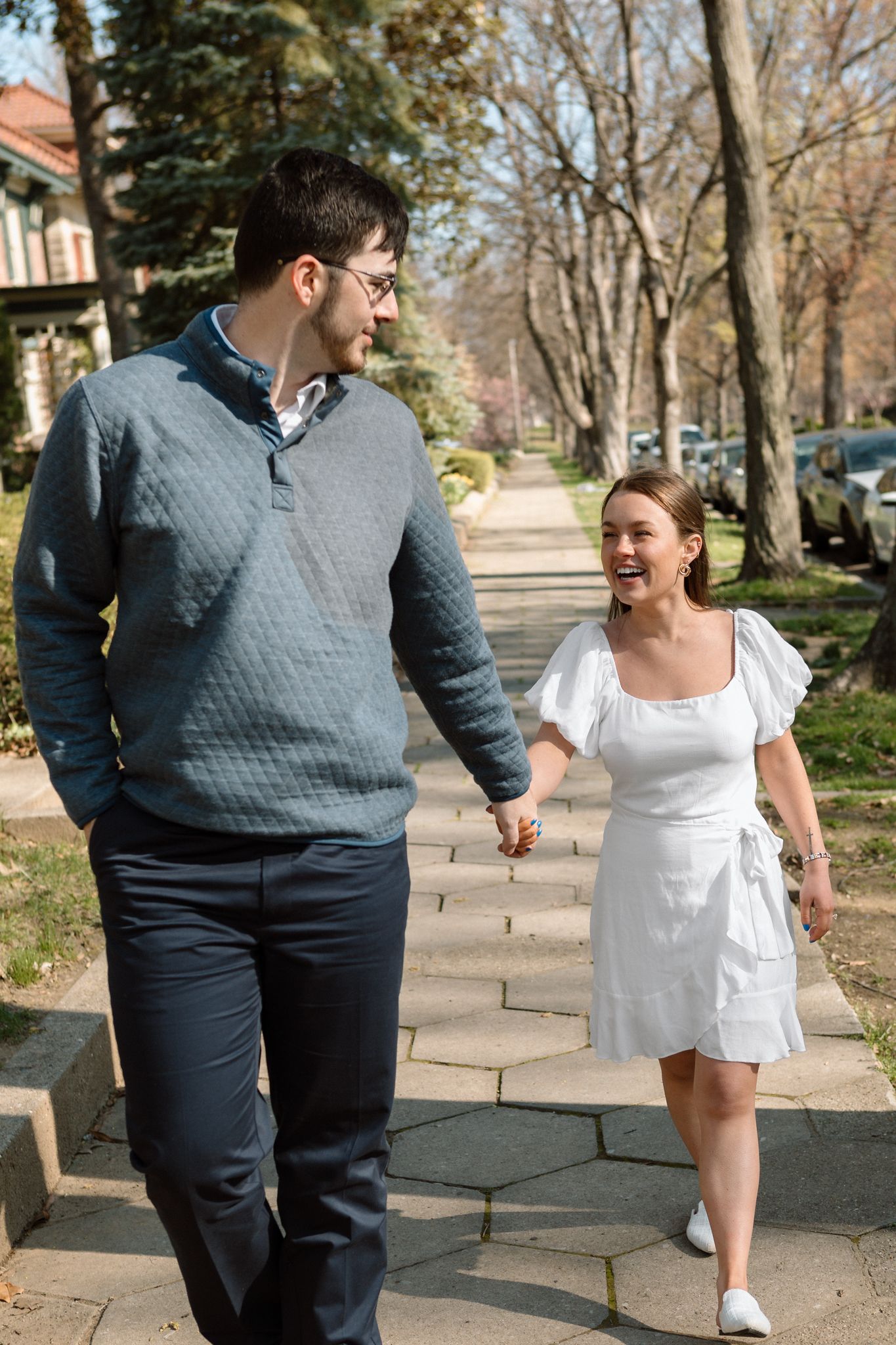 Romantic engagement photo of couple holding hands in Old Louisville's picturesque streets on a cold day