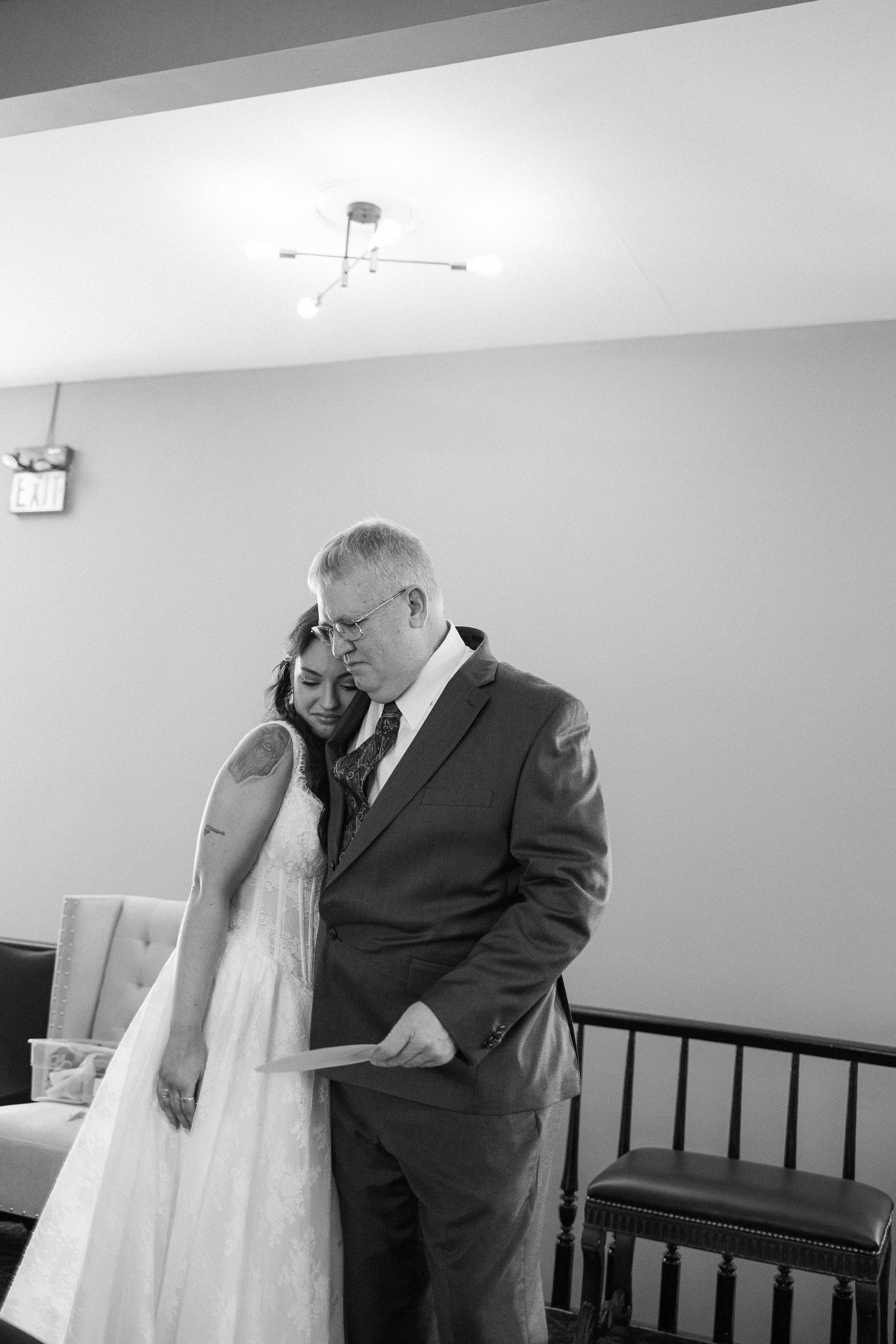 Black and white emotional moment captured during wedding preparations.