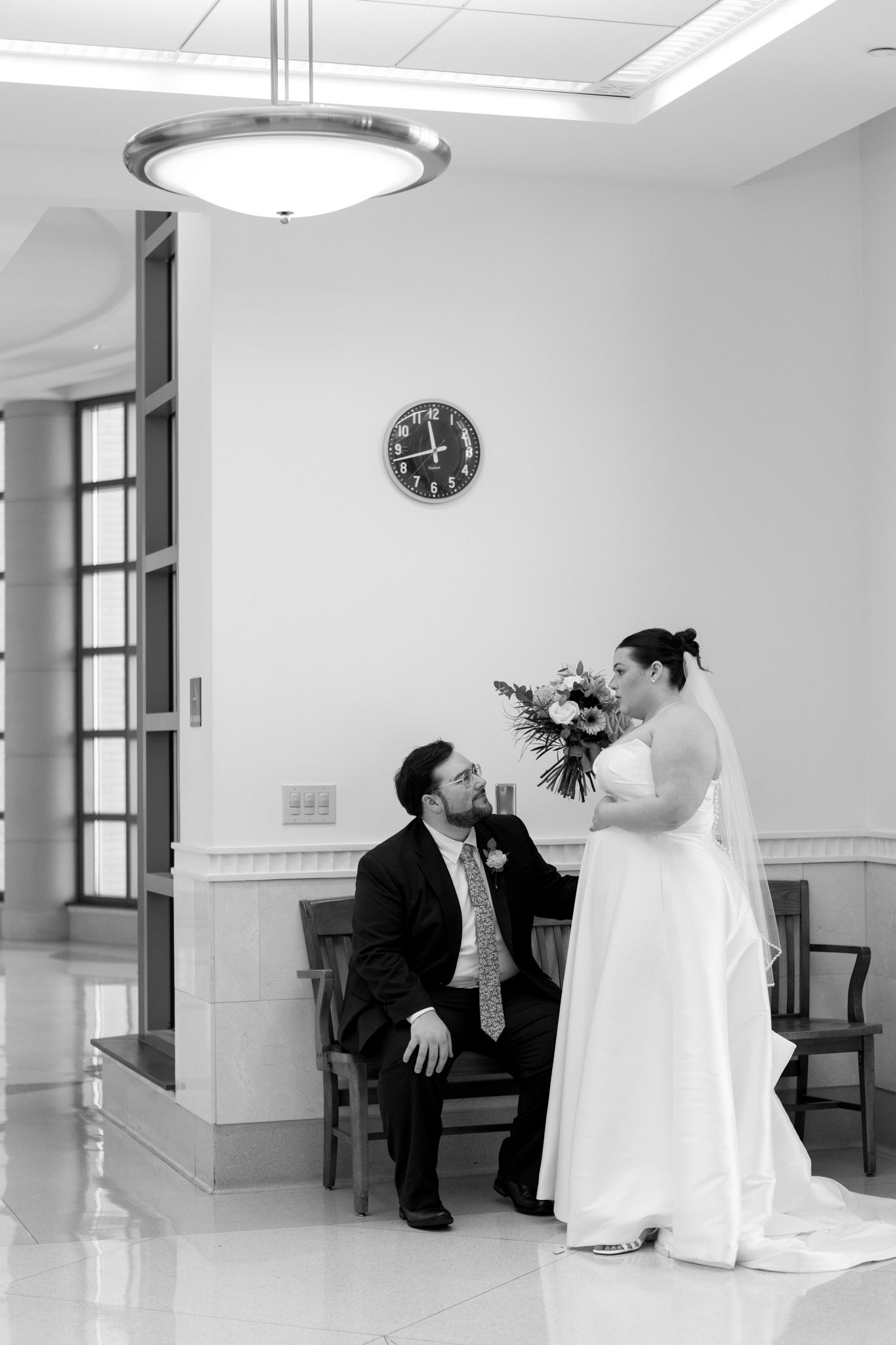 Black and white wedding photos showing a couple sharing intimate moments in a bright indoor space.