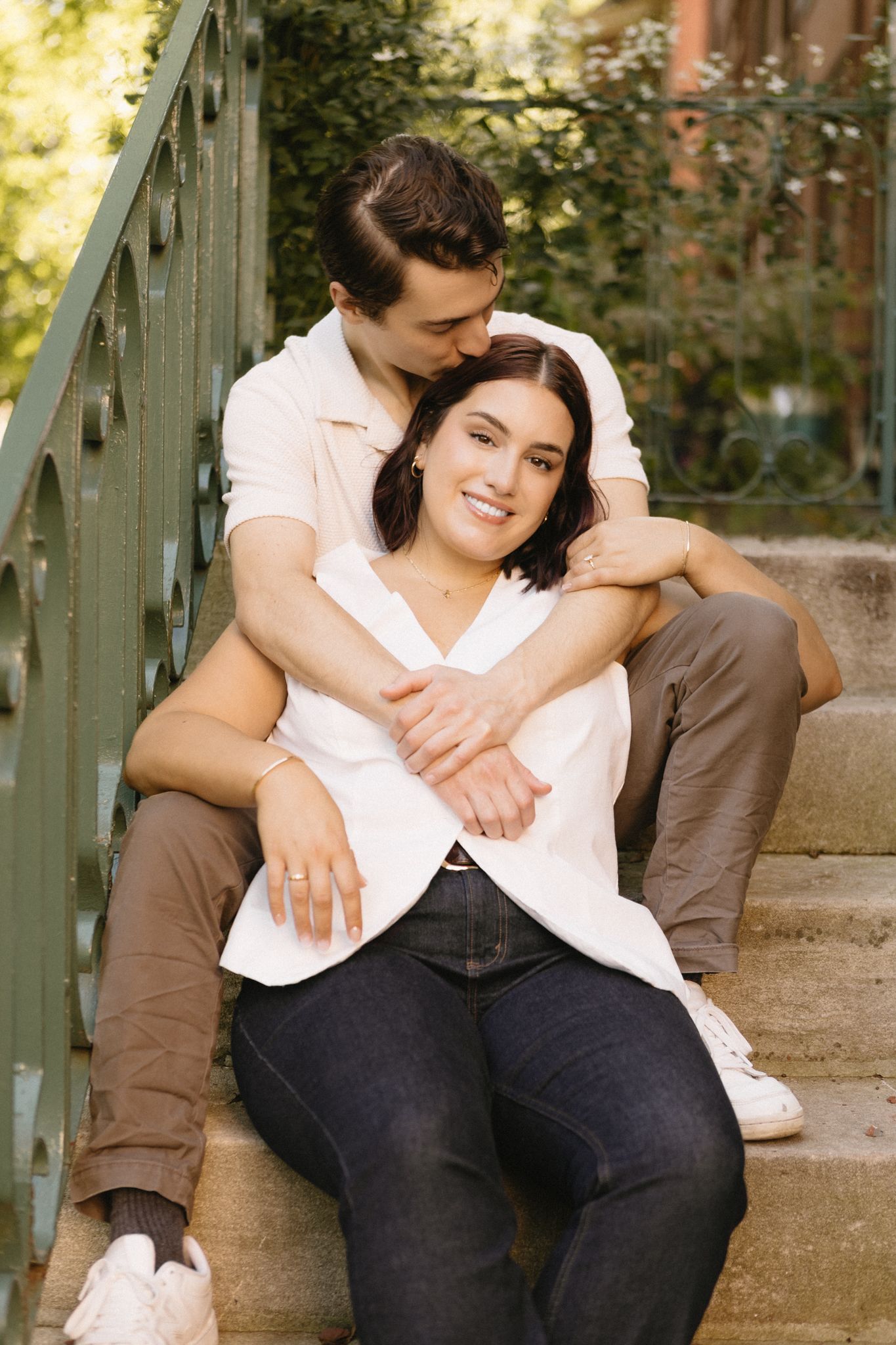 A couple sharing an intimate moment while sitting together on outdoor steps.