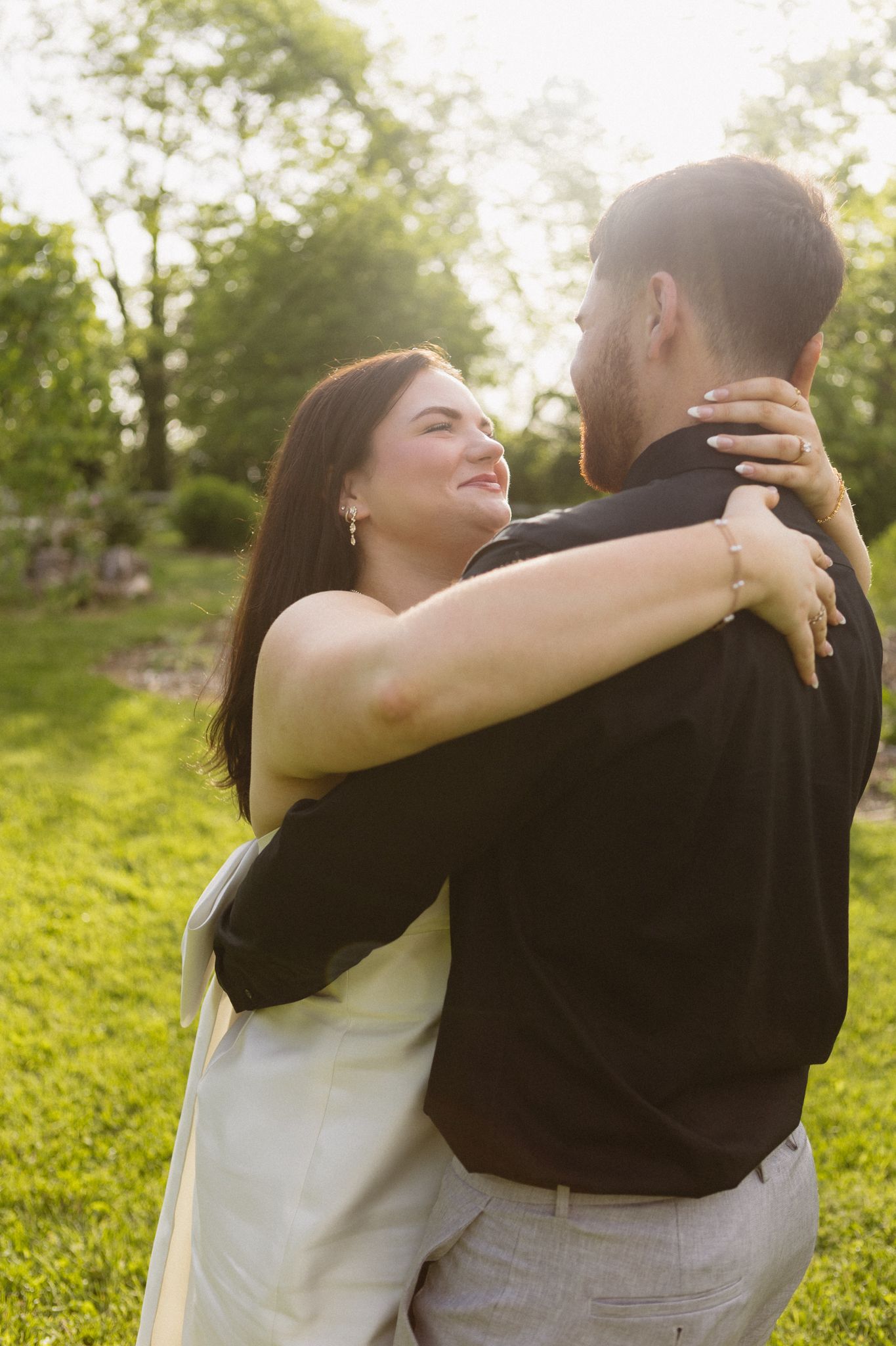 A tender moment captured between newlyweds embracing on their wedding day in a sunlit garden.