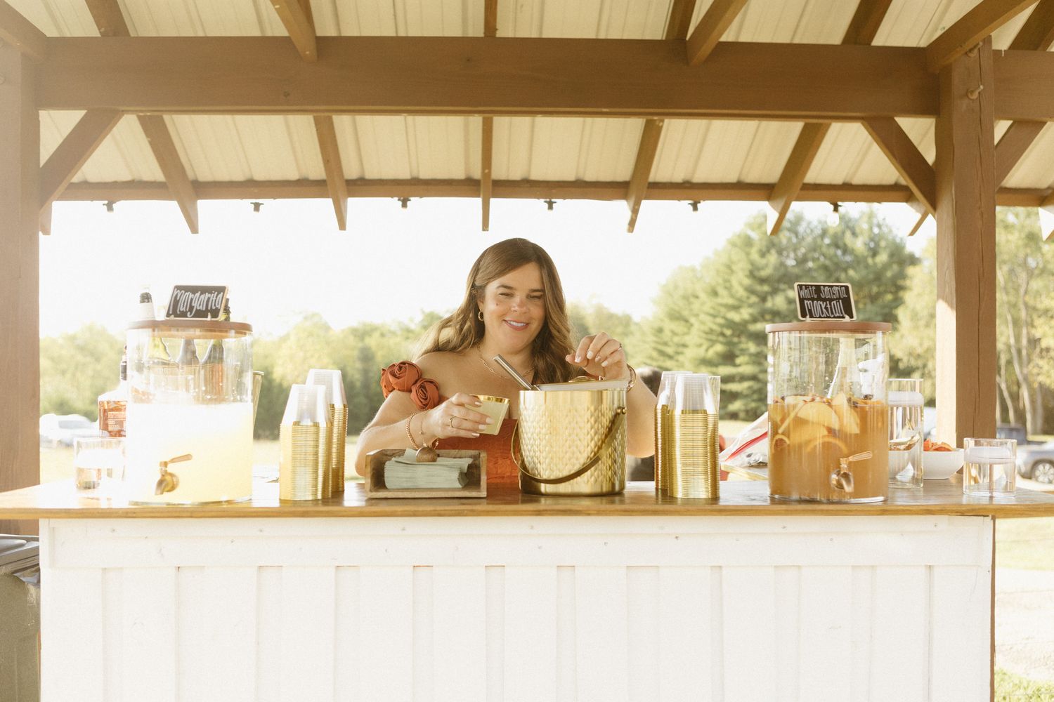 Outdoor covered pavilion venue with wooden beams and natural lighting perfect for events and gatherings.