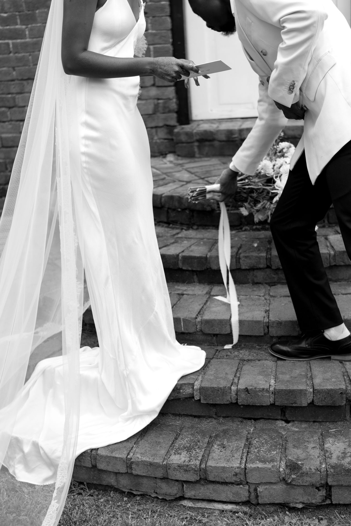 Wedding couple shares tender moments on brick patio steps.