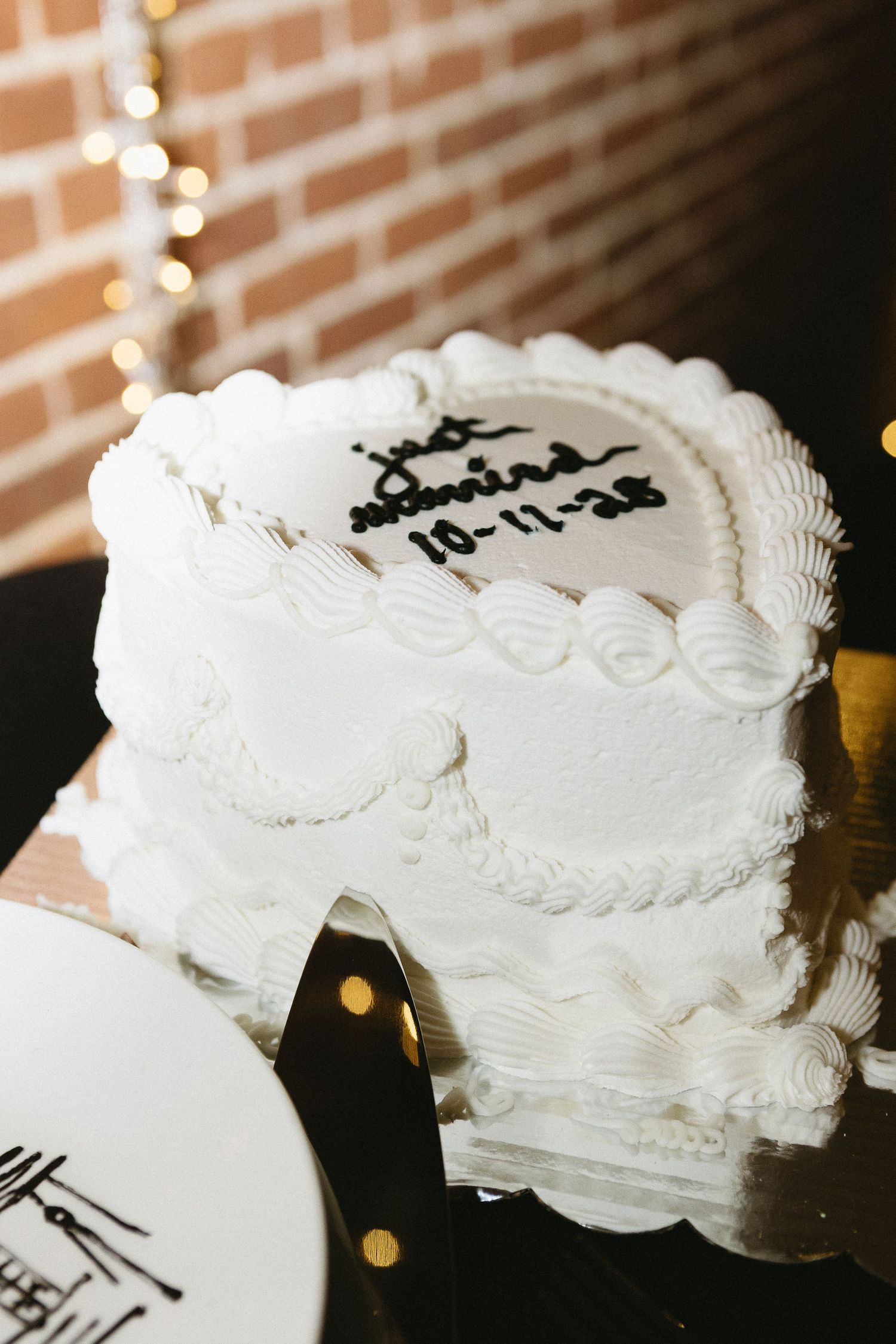 White wedding cake with delicate piped frosting details and decorative cake topper.