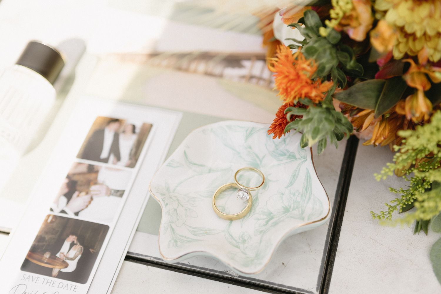 Wedding album pages displaying floral arrangements and wedding rings alongside professional photographs in an elegant layout.