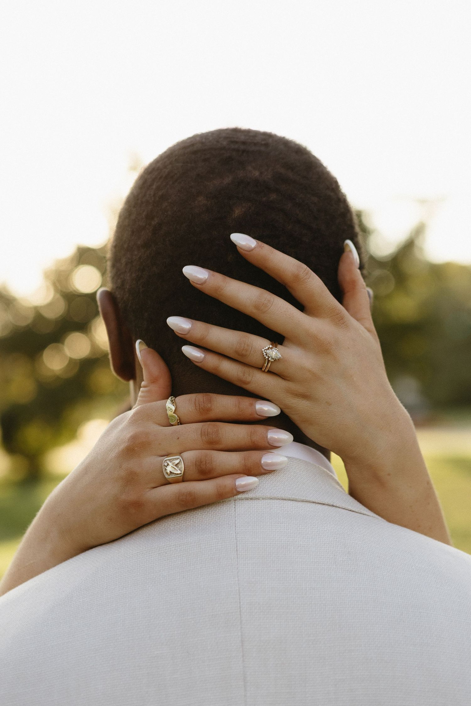 Close-up shot of hands with engagement ring embracing during a romantic moment.