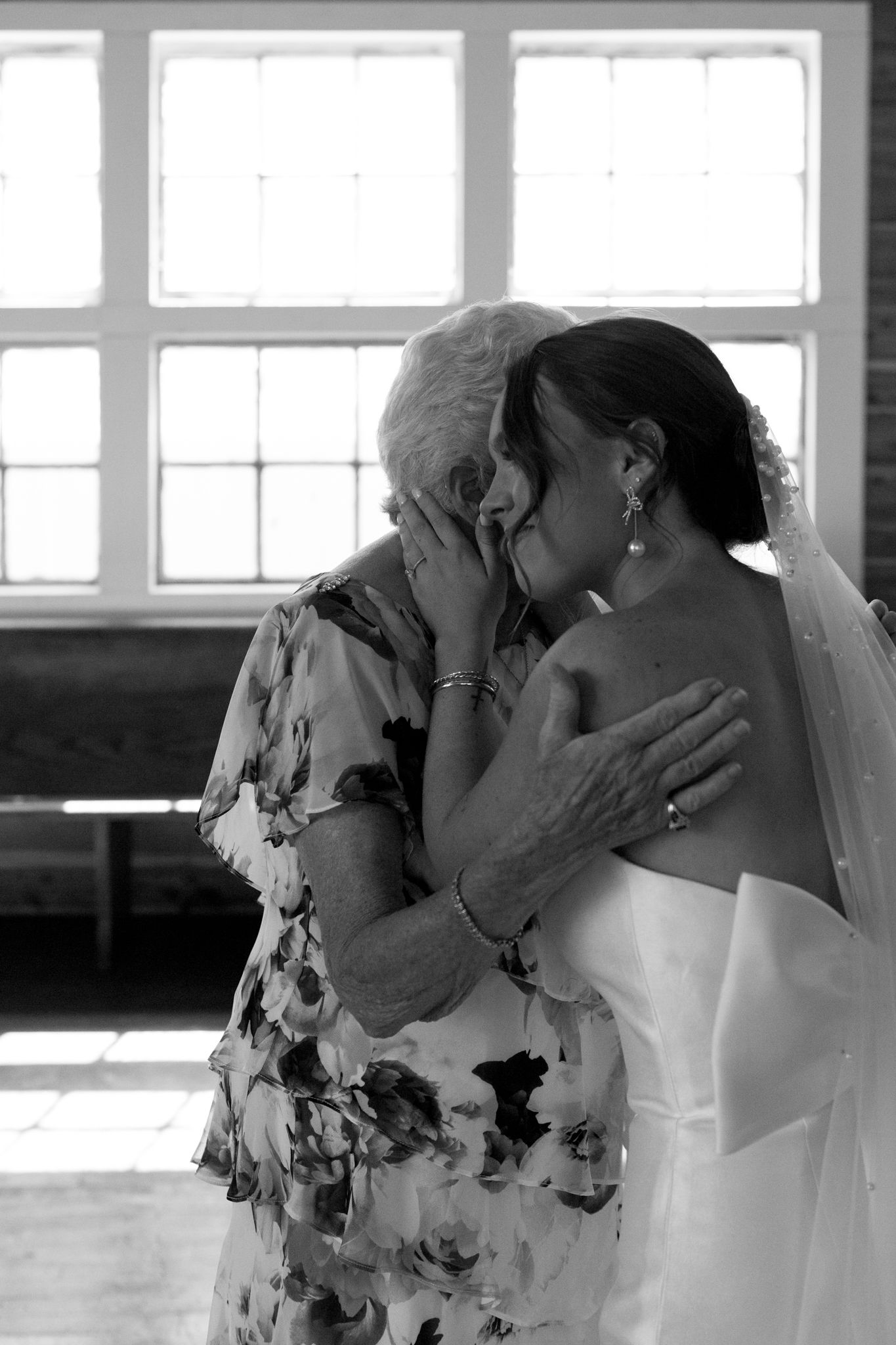 A heartfelt moment as a woman lovingly holds her hand to her grandmother's face, symbolizing care and affection.
