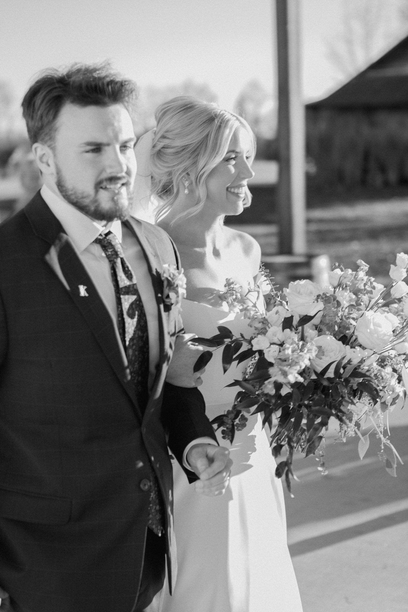 Black and white photo of bride and groom walking down the aisle at Silo Farms, capturing a timeless wedding moment