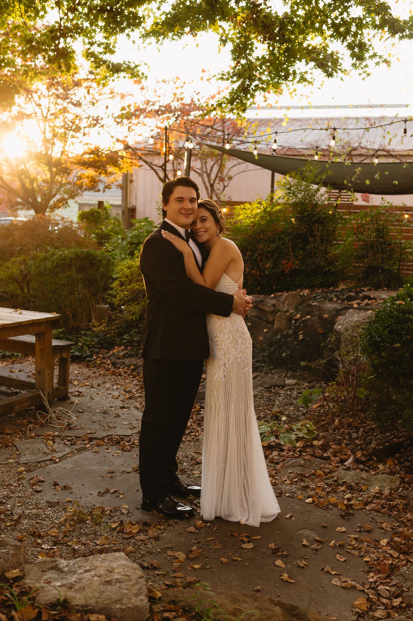 Romantic sunset portrait in a garden with string lights and fall foliage.