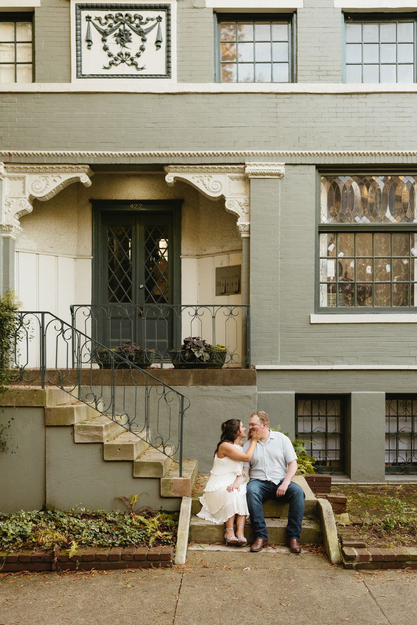 A series of four connected photos showing a couple sitting on steps outside a vintage apartment building with ornate details.