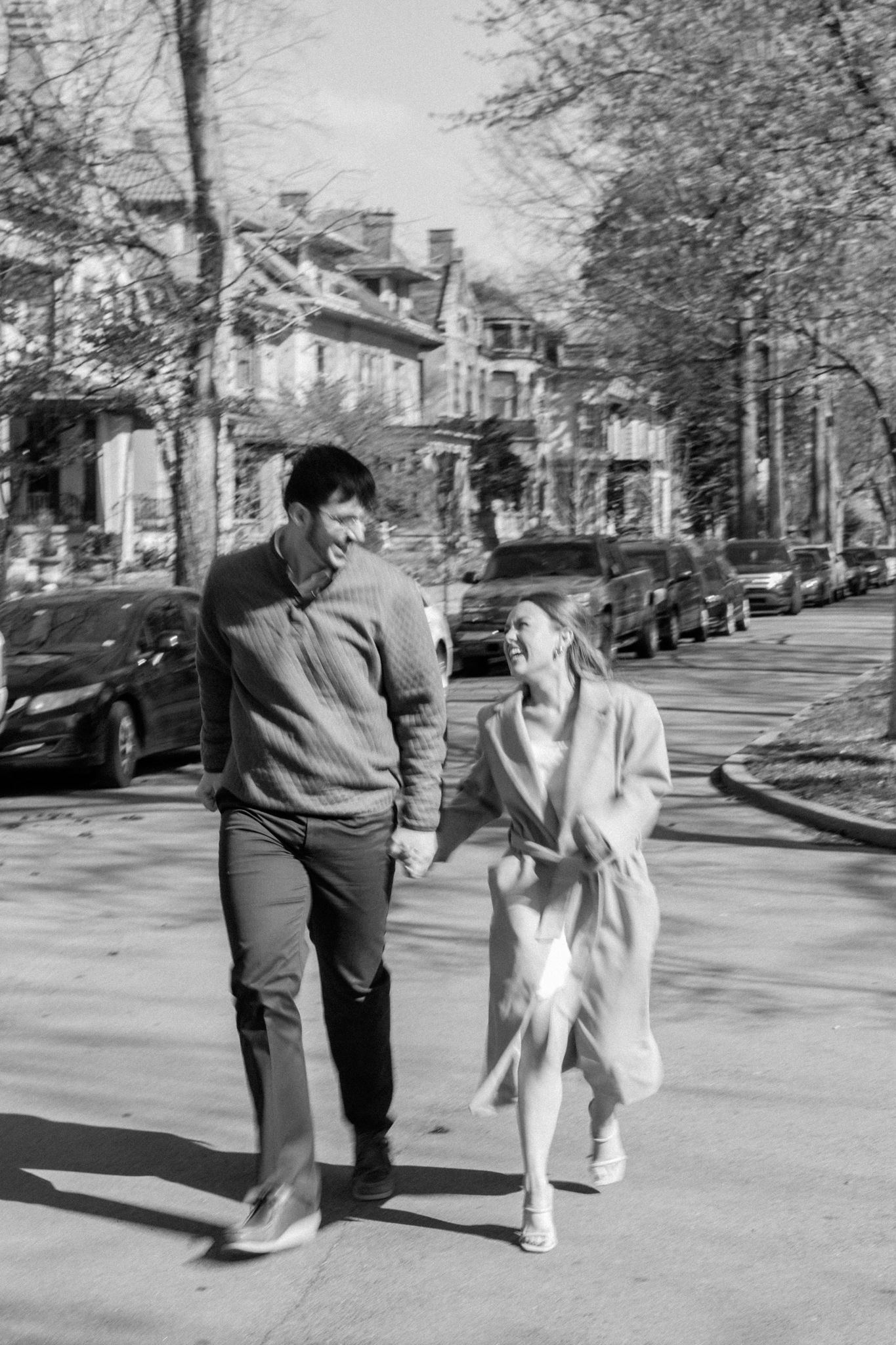 Romantic engagement photo of couple holding hands in Old Louisville's picturesque streets on a cold day