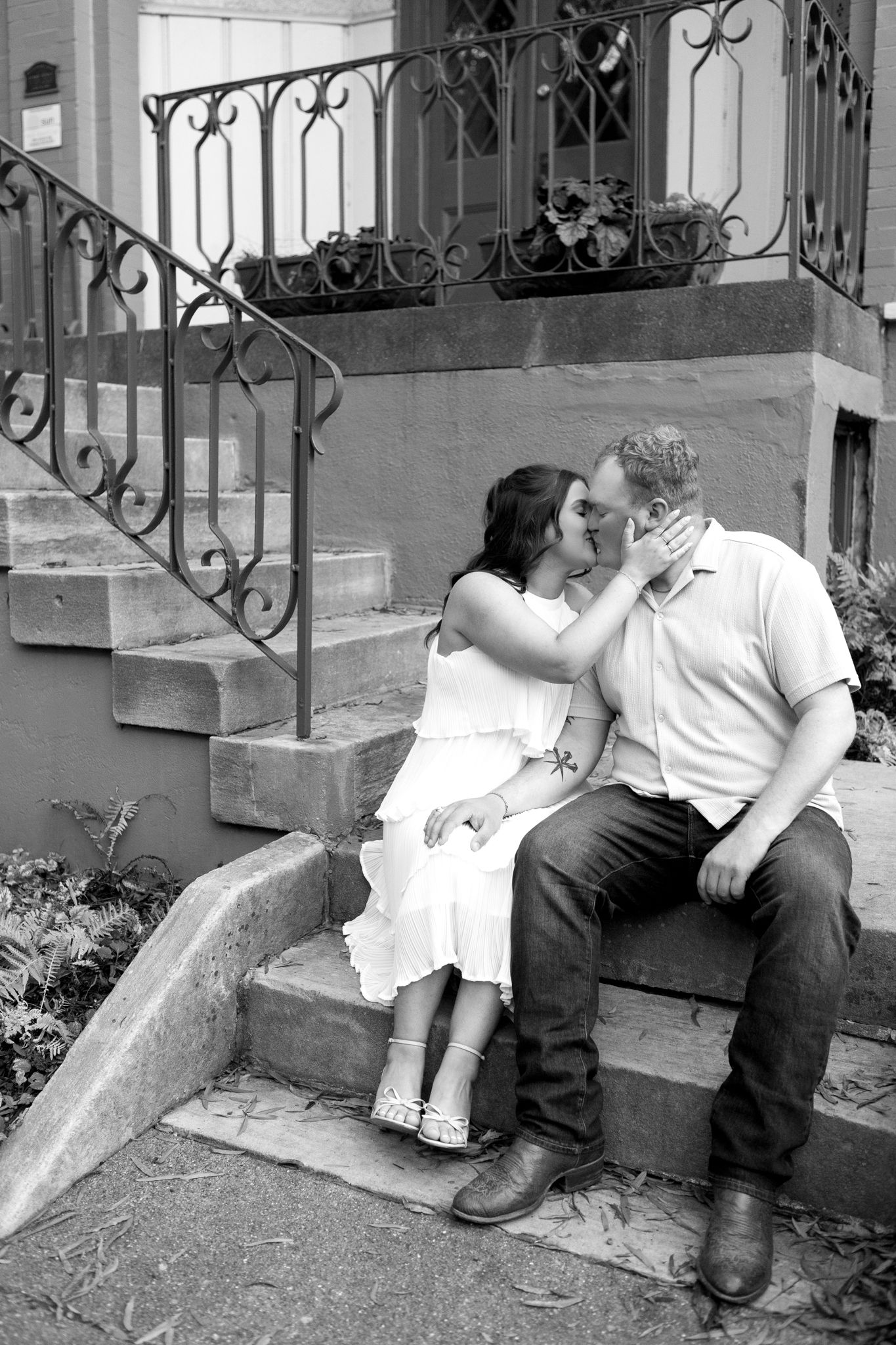 A romantic black and white photo series on vintage stone steps with ornate iron railings.