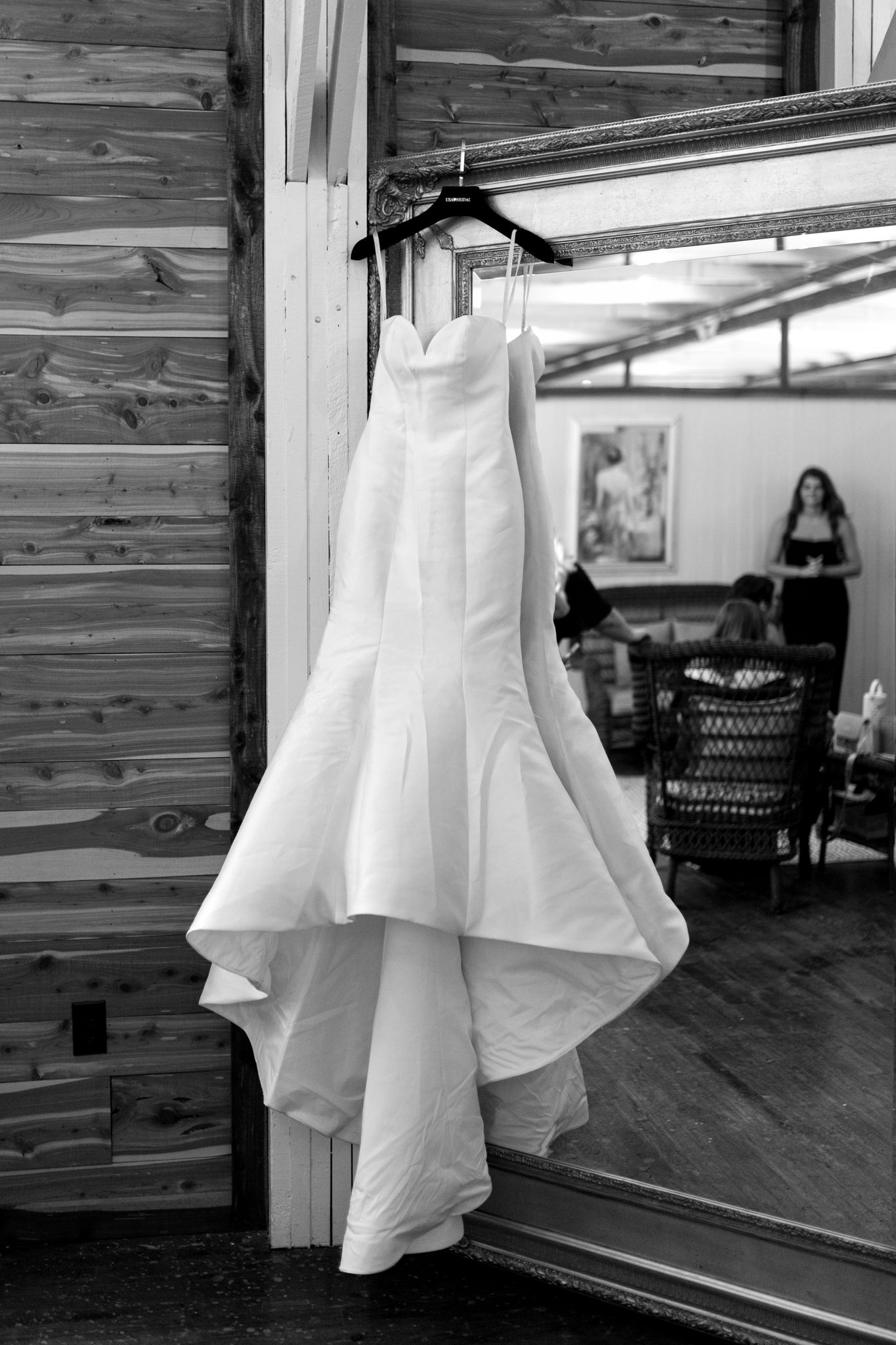 A stunning wedding dress elegantly displayed in a rustic barn setting, surrounded by the charm of a mill backdrop