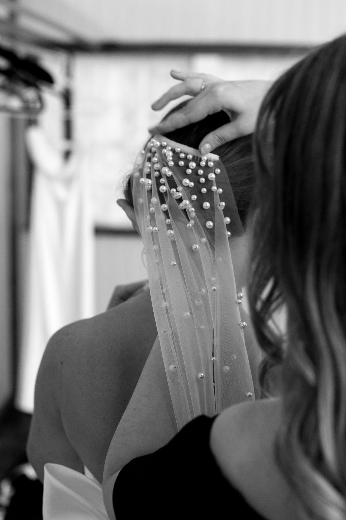 A supportive woman helps a bride with her wedding dress, showcasing a heartfelt moment filled with love and excitement f